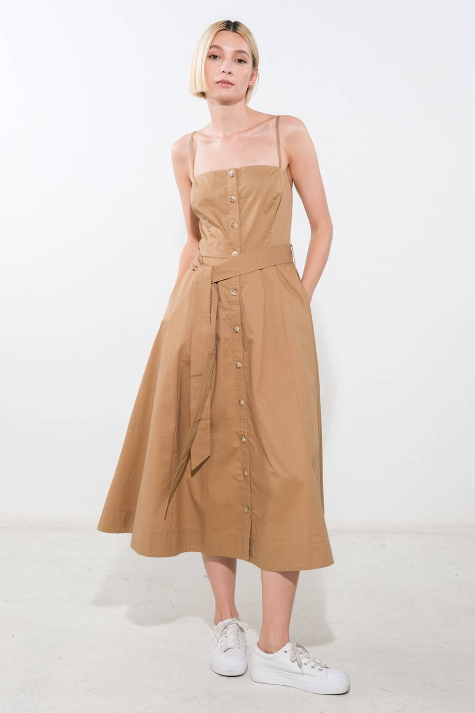 A solid woven midi dress featuring straight neckline, straps, button down, self sash belt and full skirt