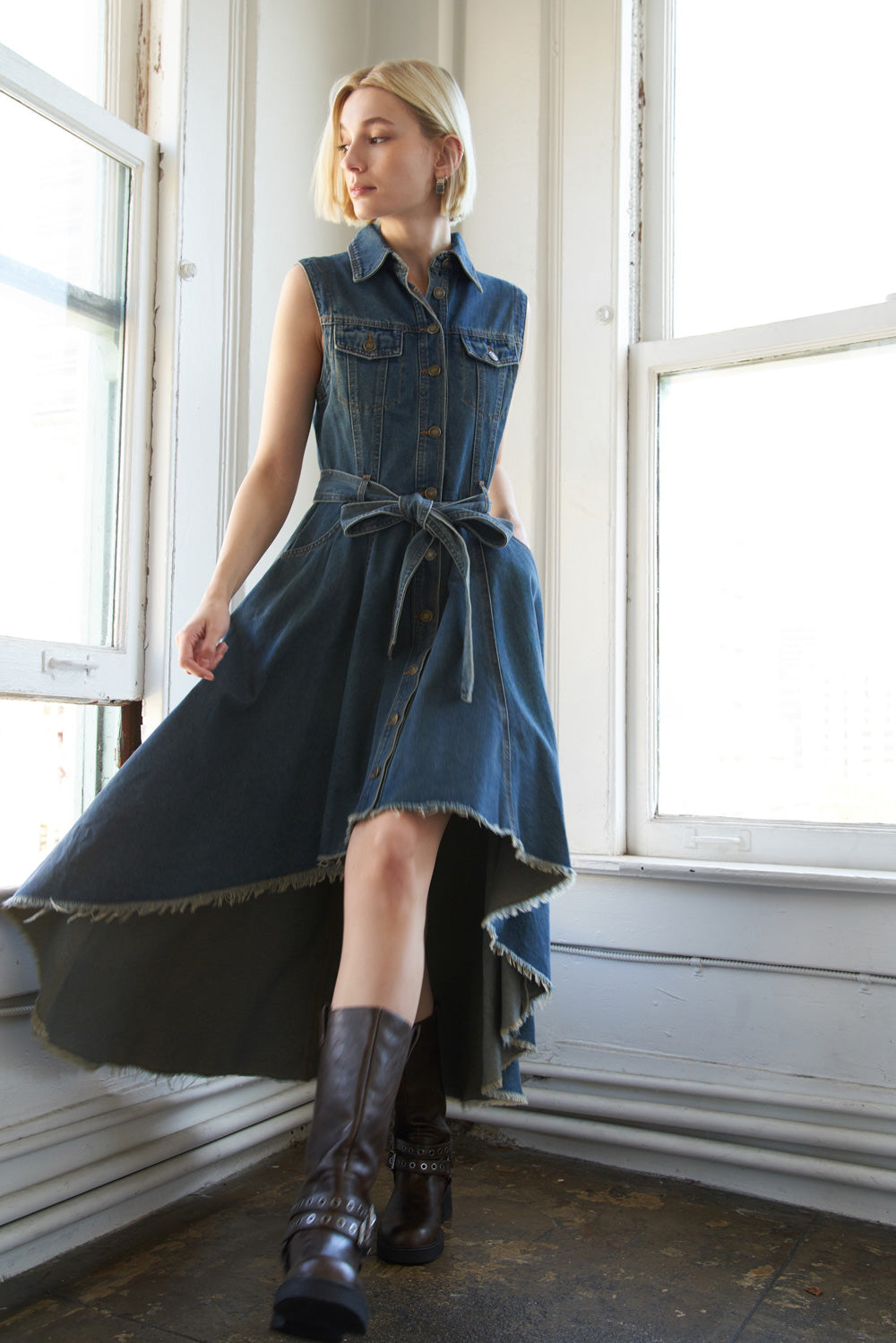A washed denim hi-lo midi dress featuring shirt collar, button down, side pockets, self sash and frayed hemline
Details:
Self : 90% Cotton 10% Polyester
Size & Fit
- Model is 5`9" And Wearing Size Small
- Measurements Taken From Size Small
- Approx. Length: 54"