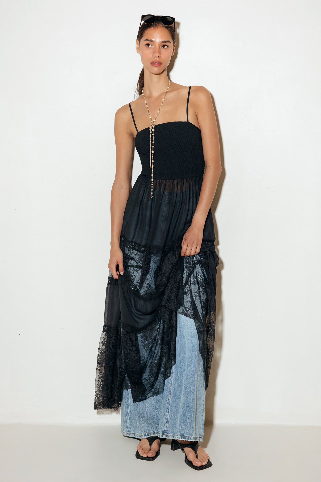 A solid maxi top featuring strap, sheer bottom with lace inset.