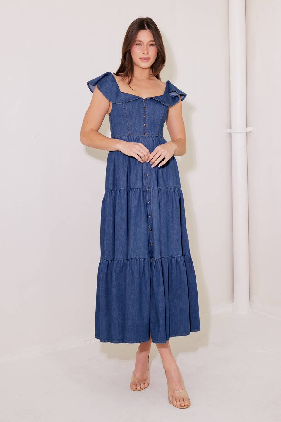 A washed denim midi dress featuring square neckline, ruffle sleeve, button down, tiered skirt and smocked back bodice