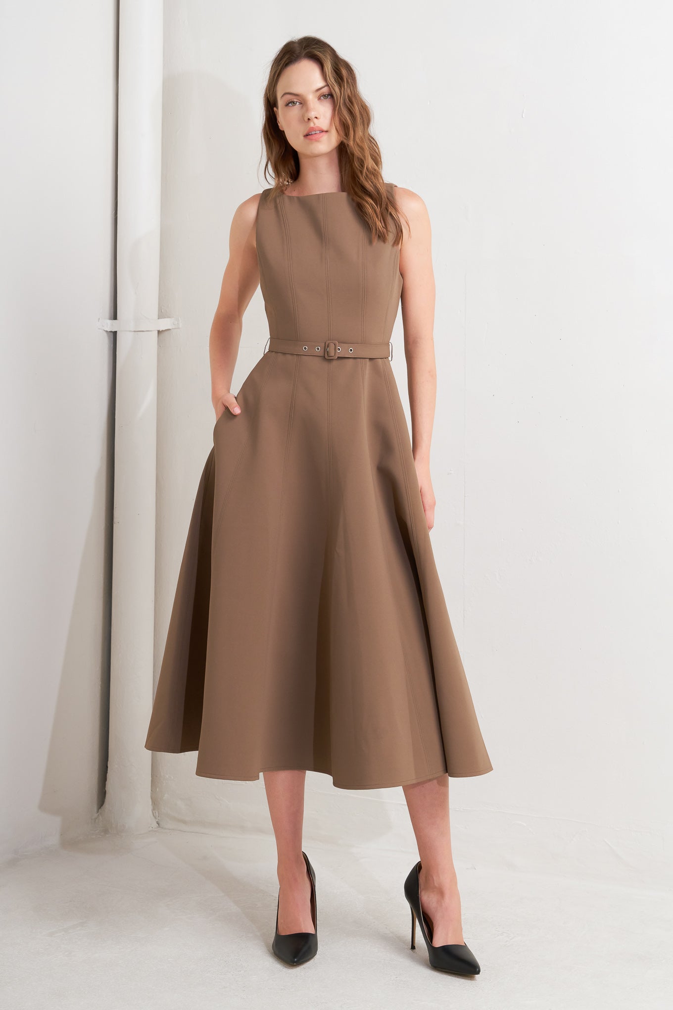 A solid woven midi dress featuring boat neckline, sleeveless, full skirt, self belt, side pocket and full skirt