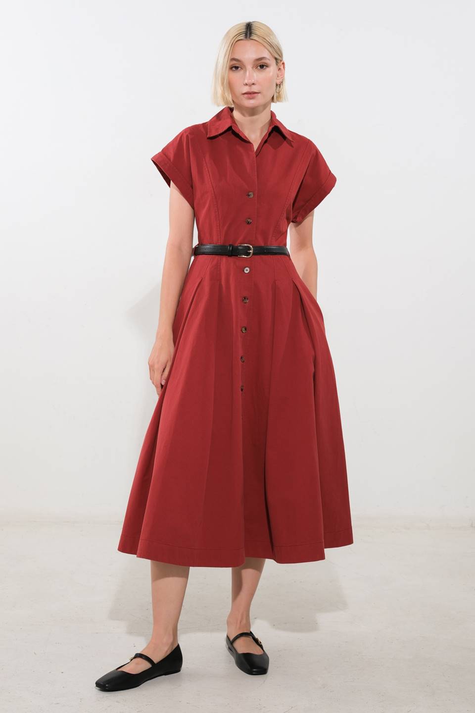 A solid woven midi dress featuring collar, cuffed sleeve, button down, belt, side pockets and full skirt