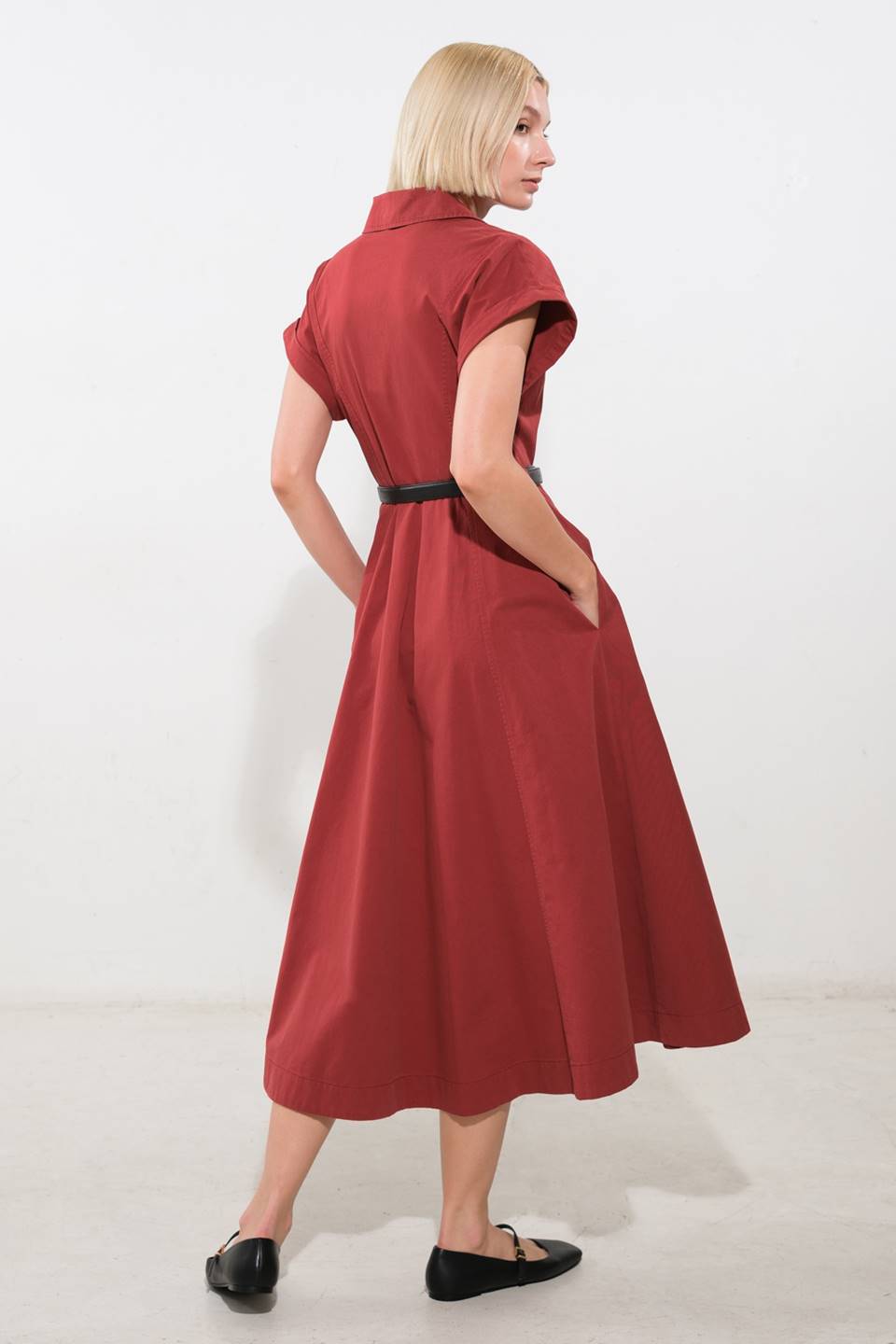 A solid woven midi dress featuring collar, cuffed sleeve, button down, belt, side pockets and full skirt