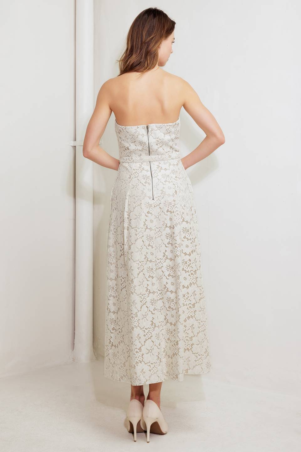 A strapless, woven lace midi dress featuring straight neckline, self belt, full skirt and back zipper closure