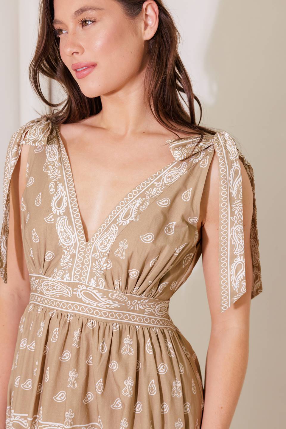 A printed woven maxi dress featuring V neckline, shoulder tie, tiered skirt and smocked back waistband