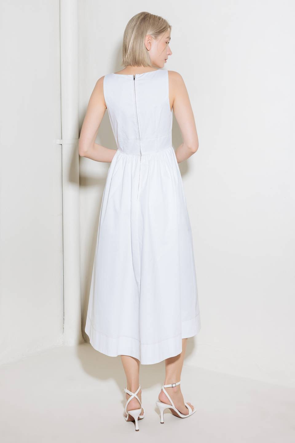 A solid woven midi dress featuring square neckline, sleeveless, front hook and eye closure, full skirt and back zipper closure.