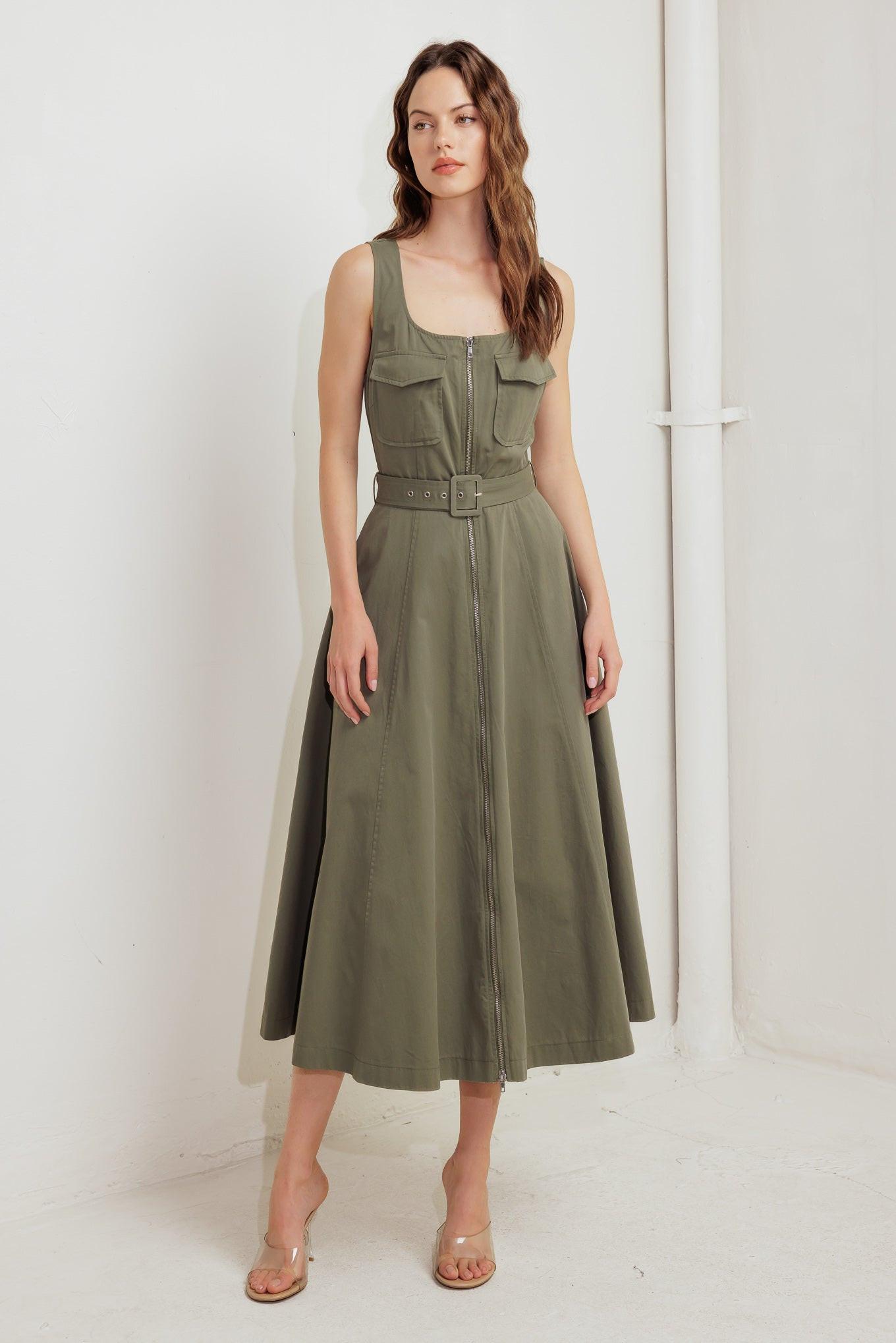 A solid woven midi dress featuring square neckline, sleeveless, front pockets, zipper closure, self belt and circle skirt