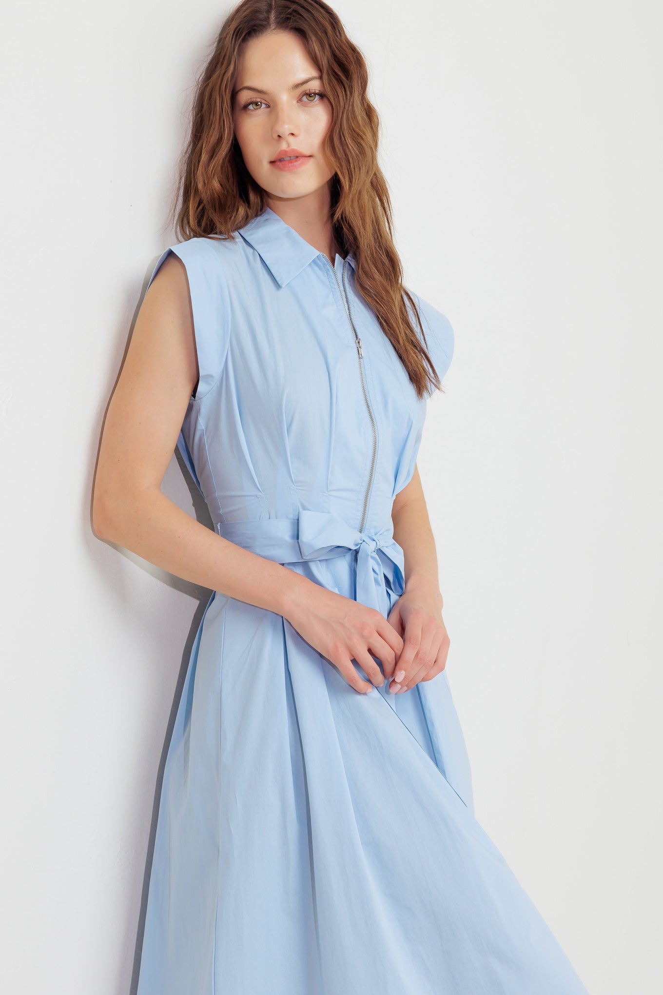 A solid woven midi dress featuring collar, short sleeve, front zipper closure and self sash tie