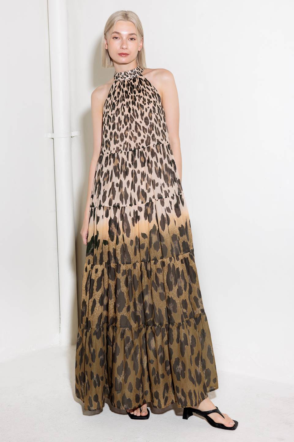A printed woven maxi dress featuring halter neckline, tiered skirt and back neck tie detail.