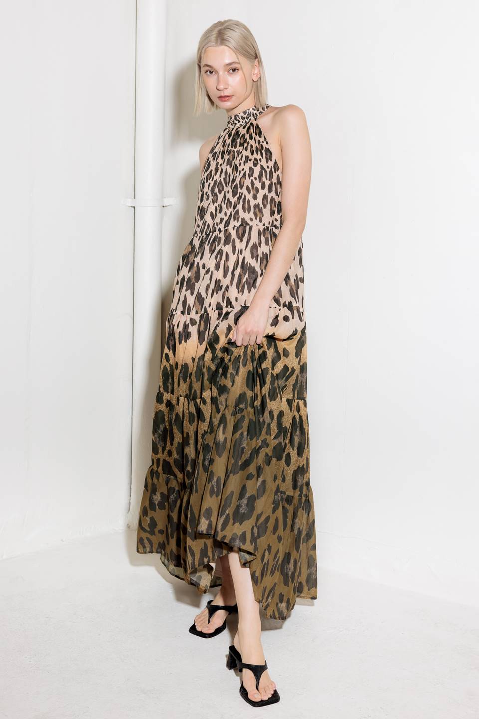 A printed woven maxi dress featuring halter neckline, tiered skirt and back neck tie detail.