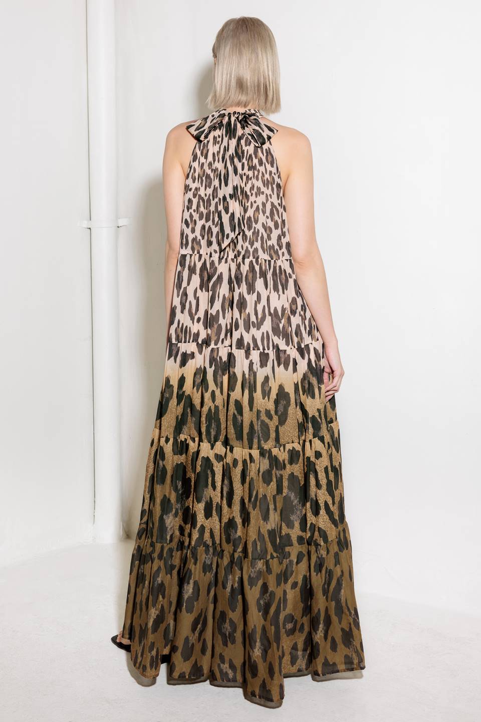 A printed woven maxi dress featuring halter neckline, tiered skirt and back neck tie detail.
