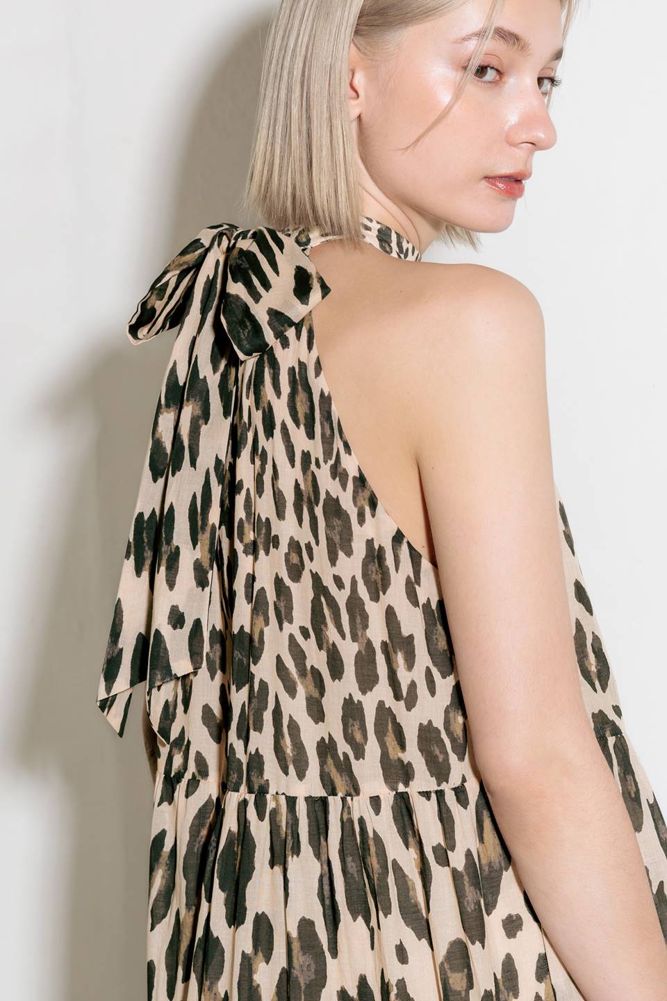 A printed woven maxi dress featuring halter neckline, tiered skirt and back neck tie detail.