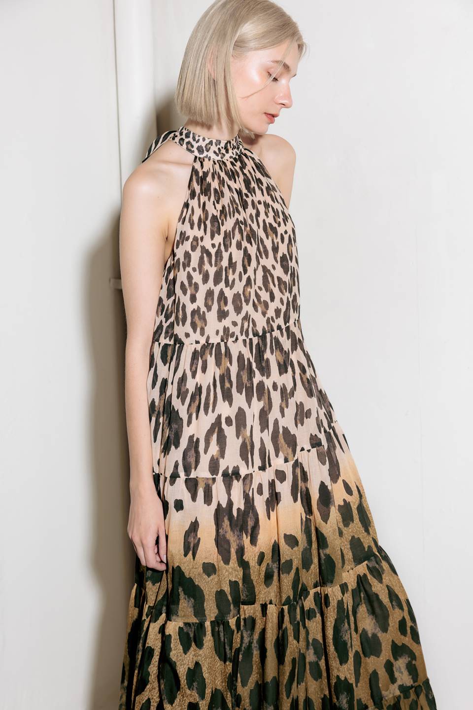 A printed woven maxi dress featuring halter neckline, tiered skirt and back neck tie detail.