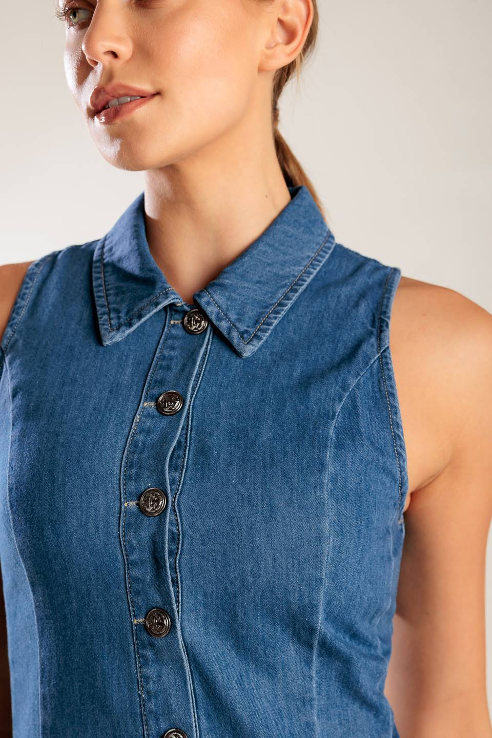 A washed denim mini dress featuring collar, button down, fitted waist and inverted pleats