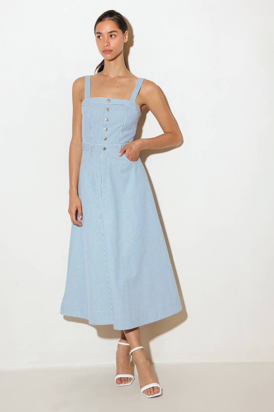 A striped woven midi dress featuring straight neckline, straps, front button down and zipper closure and A line skirt.