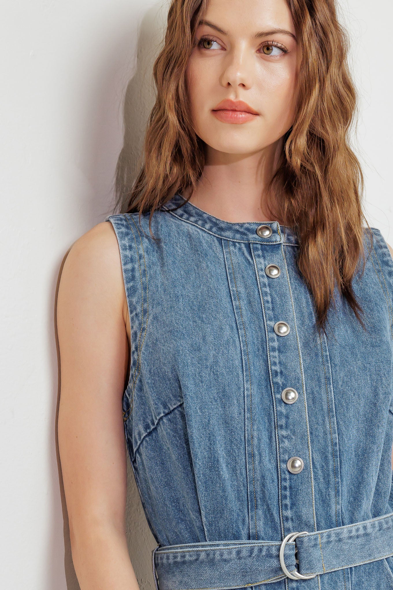 A washed denim midi dress featuring round neckline, sleeveless, button down, circle skirt and self belt