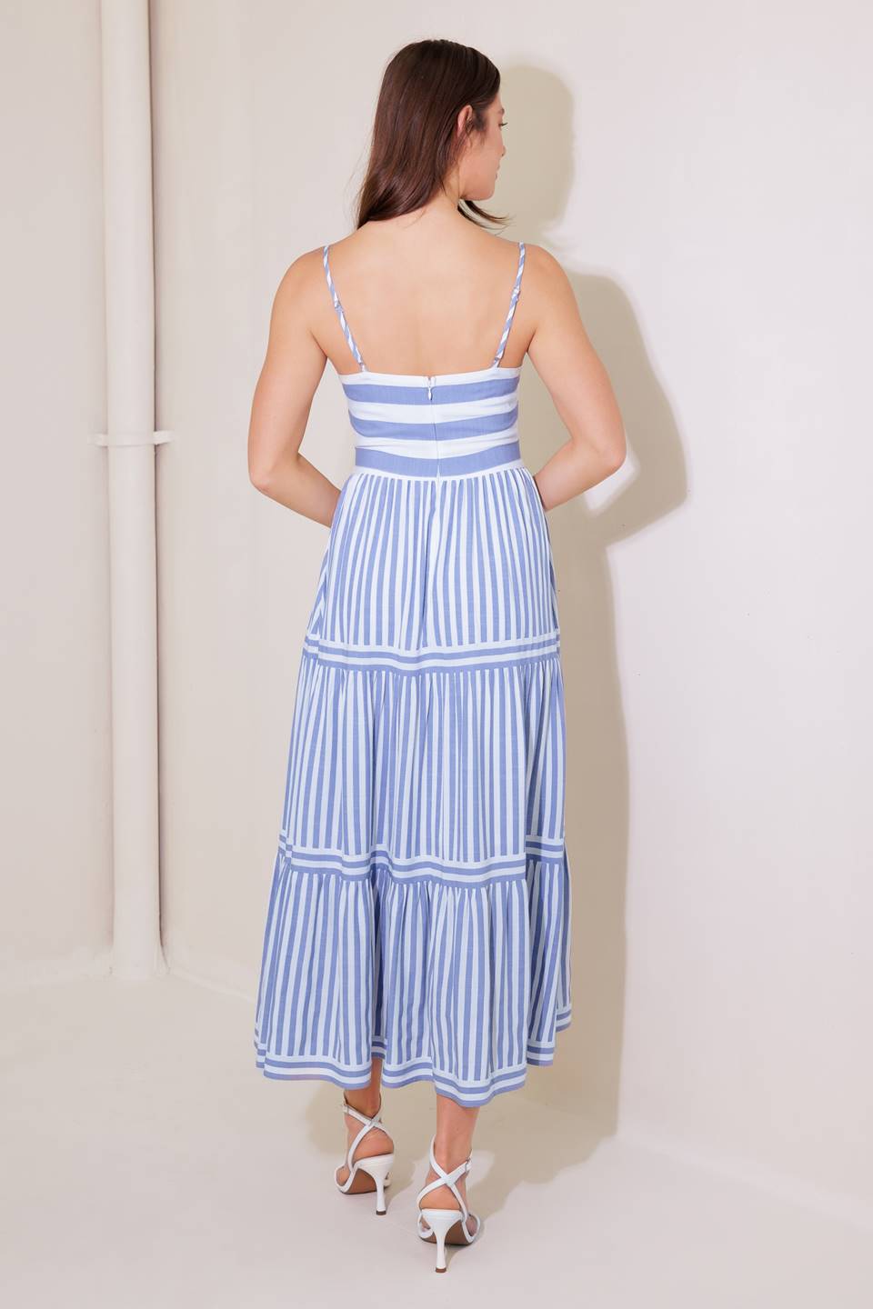 A striped woven midi dress featuring straight neckline, straps, tiered skirt and back zipper closure