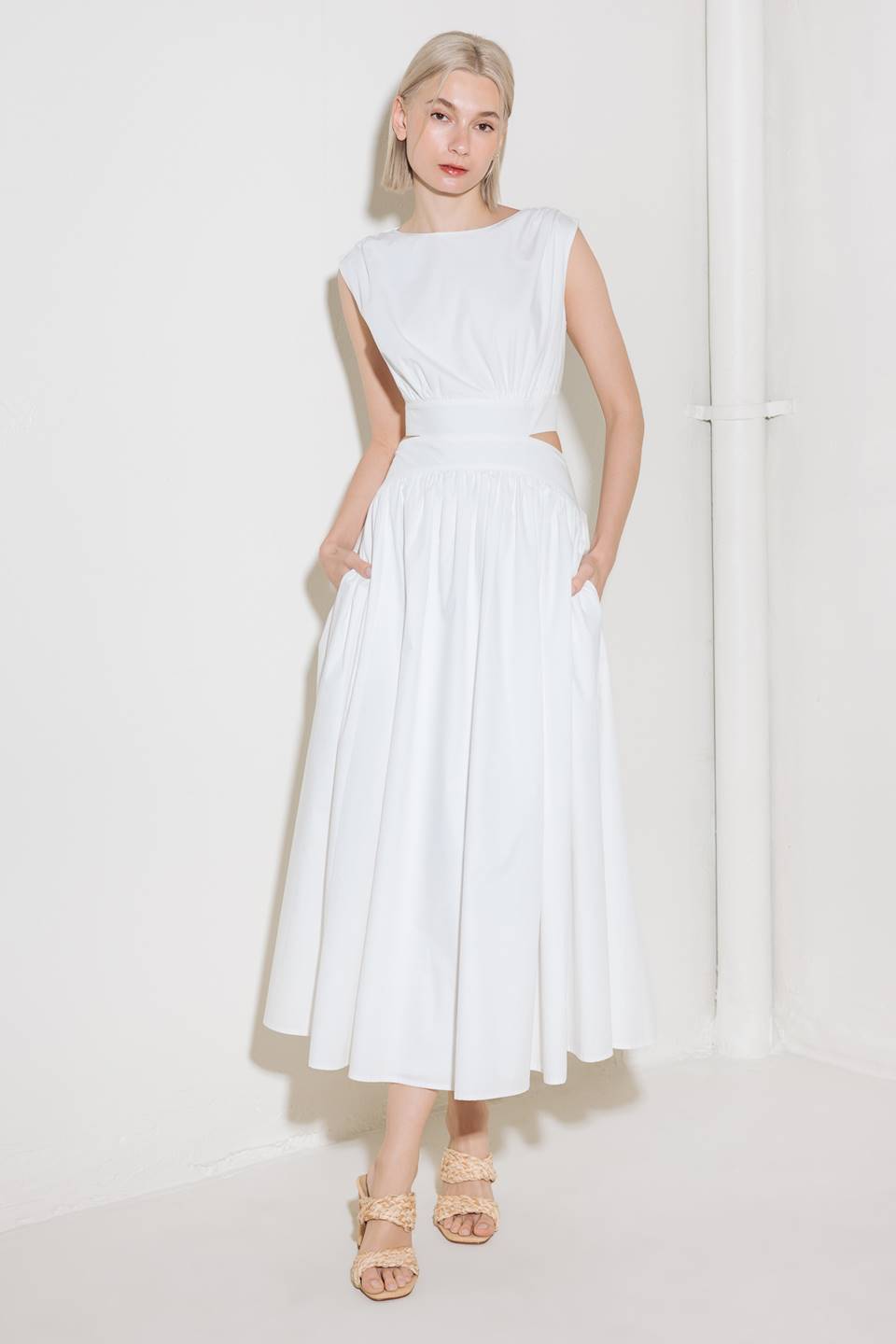A solid woven midi dress featuring round neckline, sleeveless, side/back cut out, full skirt, side pocket and back zipper closure.