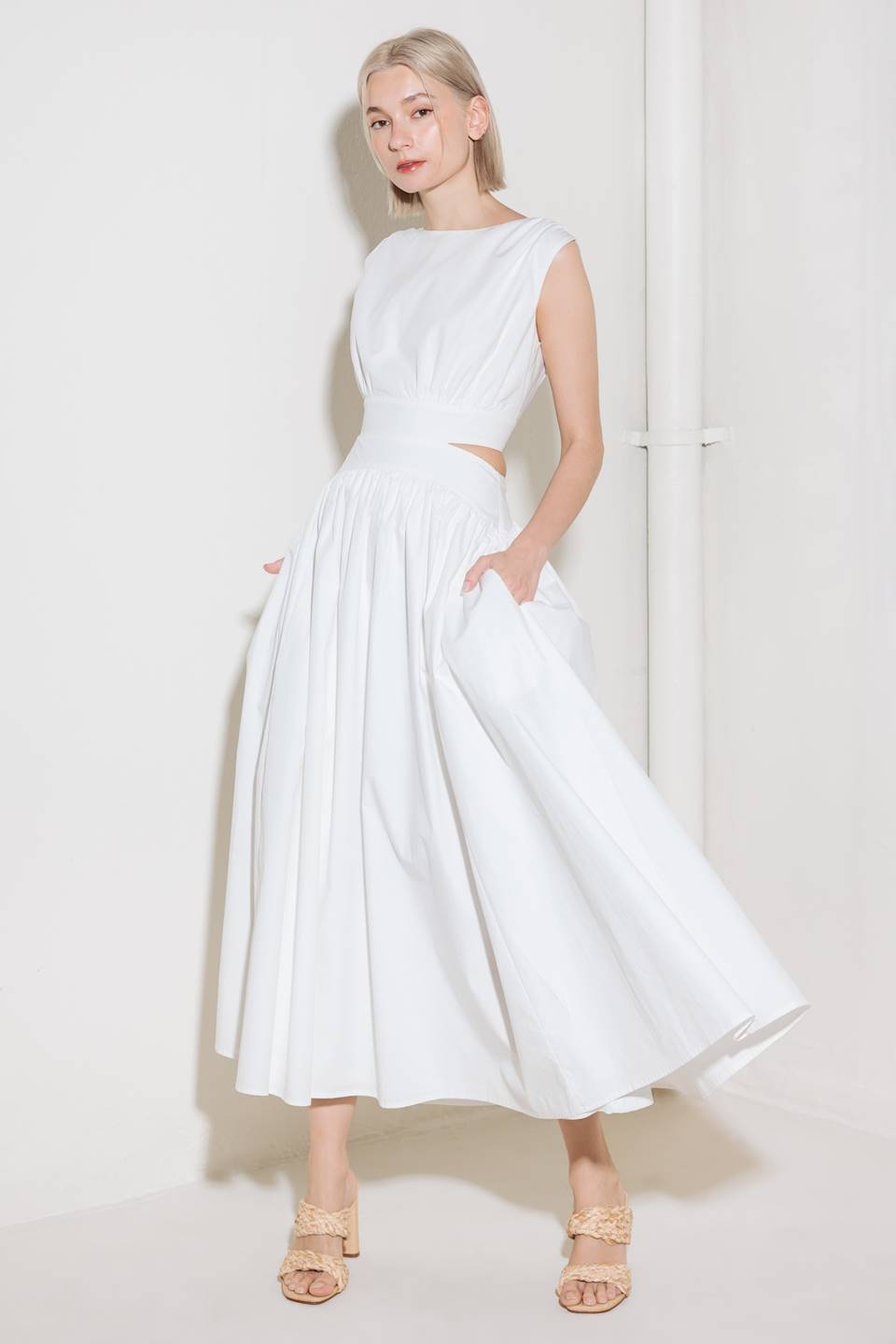 A solid woven midi dress featuring round neckline, sleeveless, side/back cut out, full skirt, side pocket and back zipper closure.