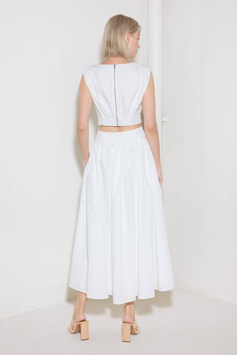 A solid woven midi dress featuring round neckline, sleeveless, side/back cut out, full skirt, side pocket and back zipper closure.
