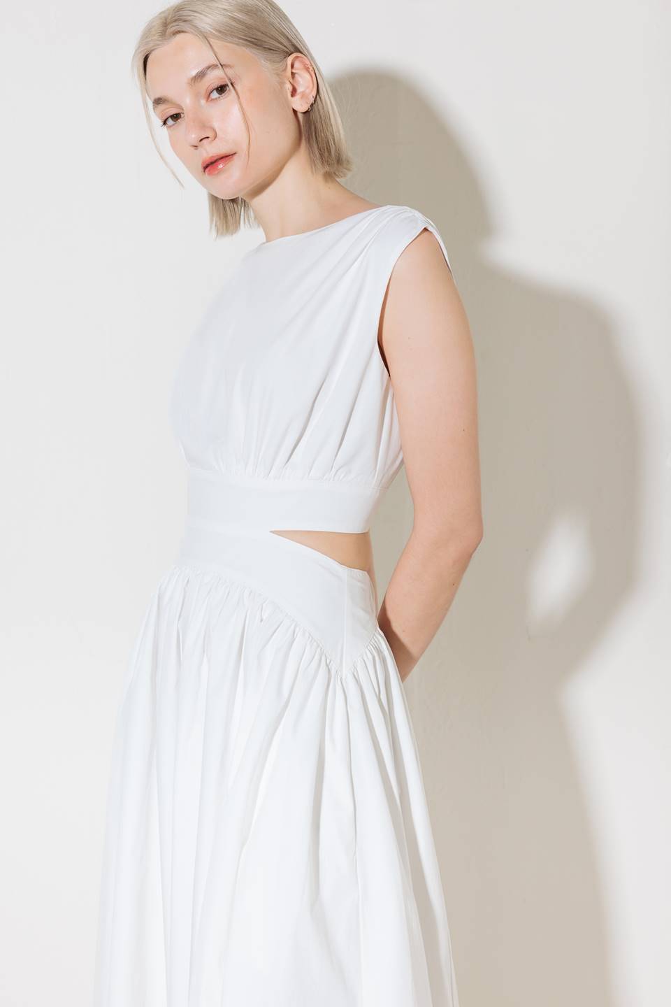 A solid woven midi dress featuring round neckline, sleeveless, side/back cut out, full skirt, side pocket and back zipper closure.