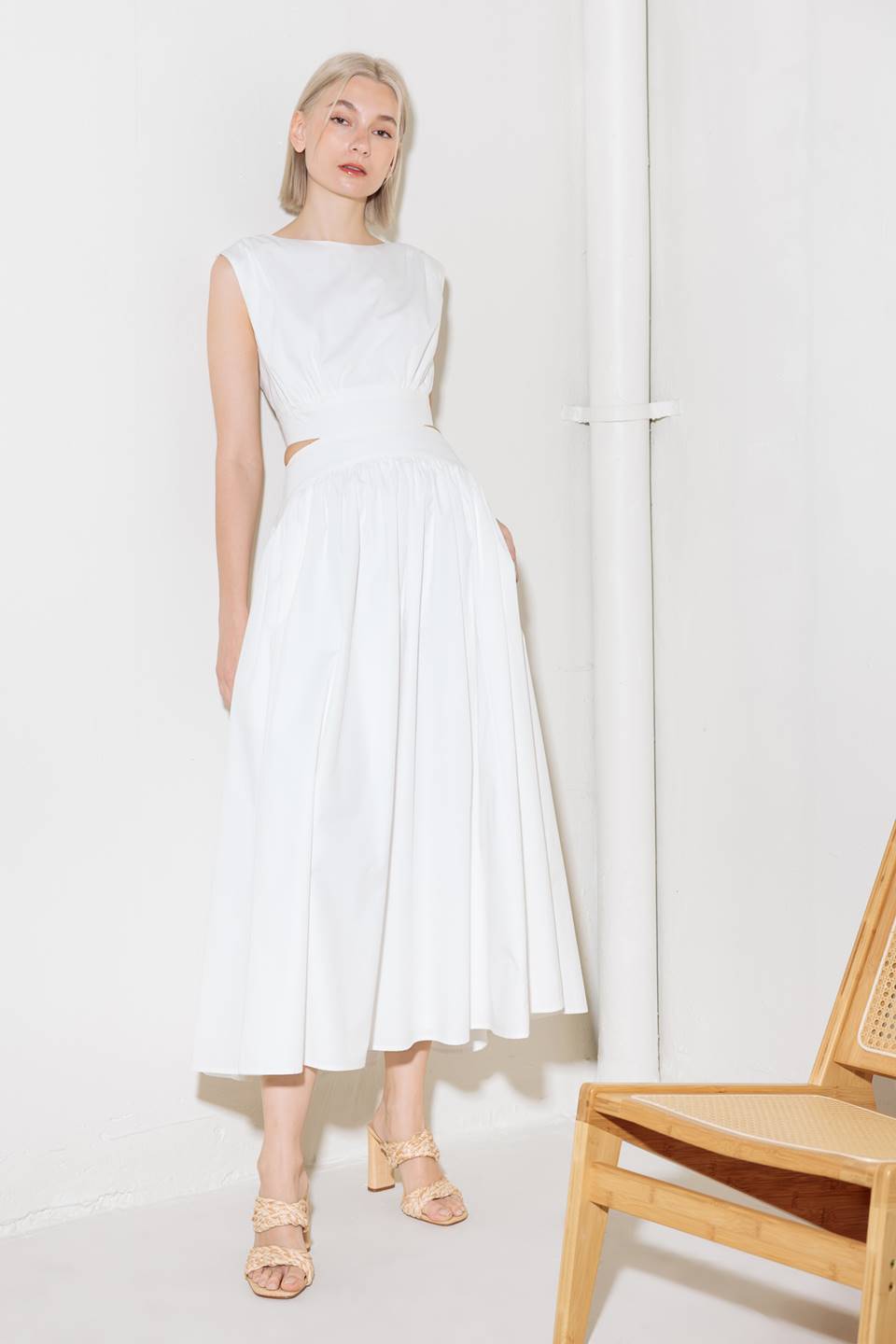 A solid woven midi dress featuring round neckline, sleeveless, side/back cut out, full skirt, side pocket and back zipper closure.
