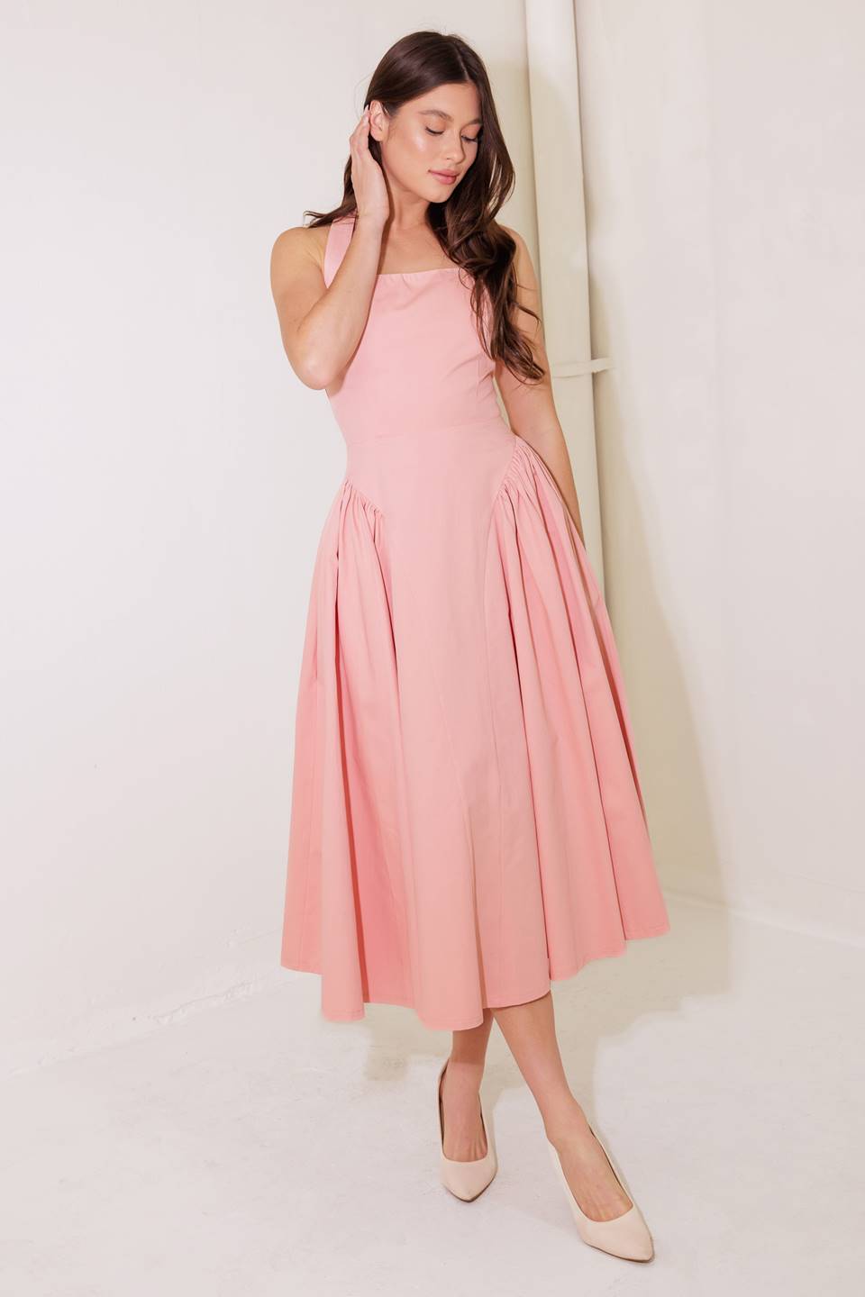 A woven midi dress featuring halter neckline, full skirt with side shirring detail and bare back with zipper and button closure