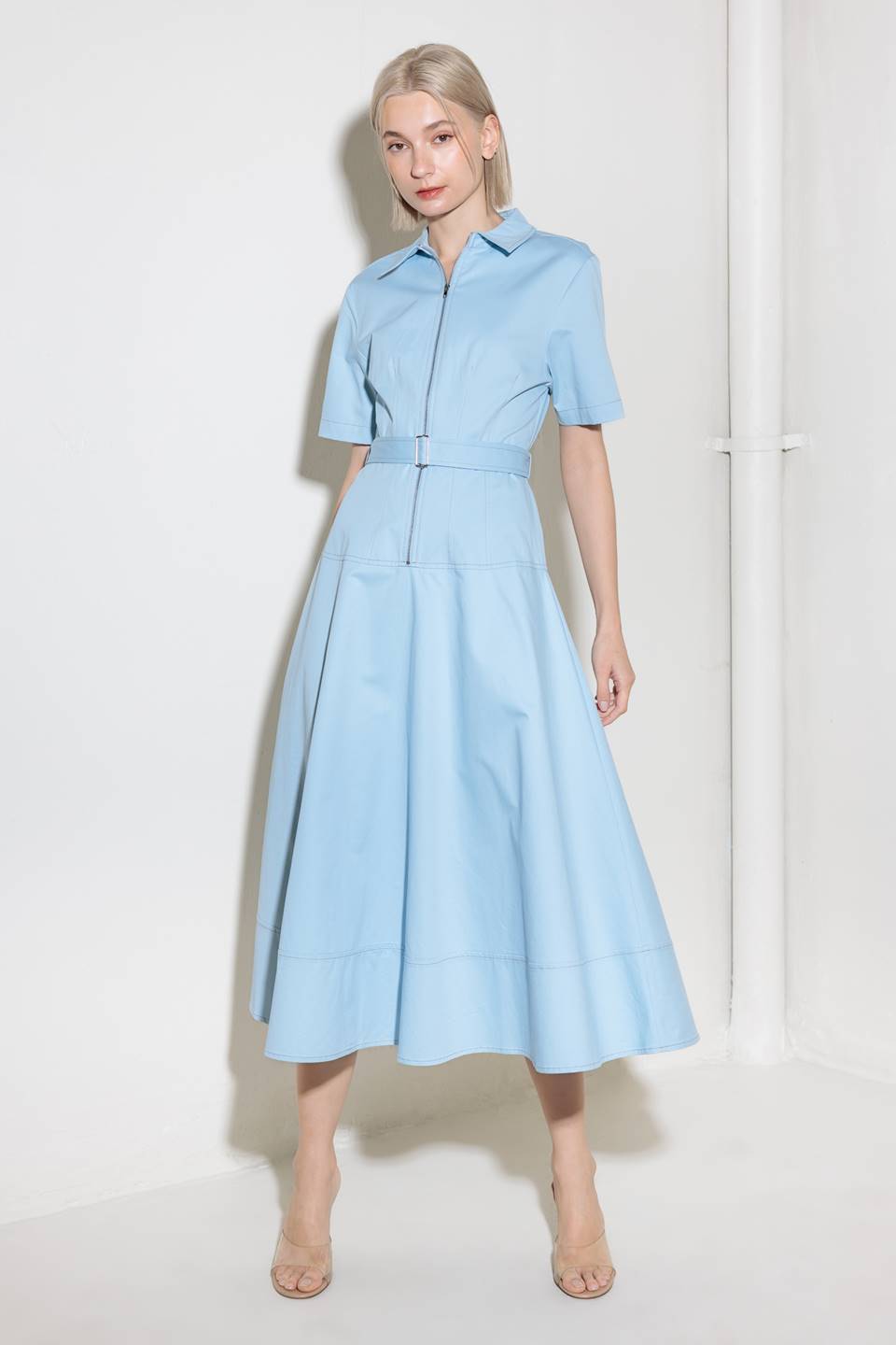 A solid woven shirt dress featuring collar, short sleeve, self belt, circle skirt and front zipper closure.
