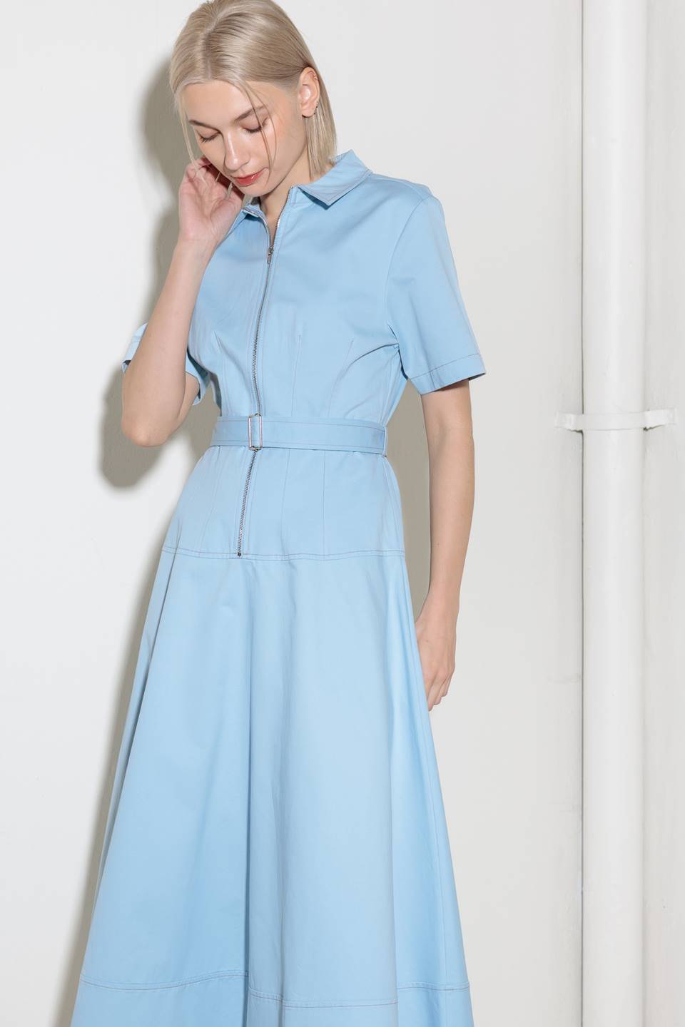 A solid woven shirt dress featuring collar, short sleeve, self belt, circle skirt and front zipper closure.