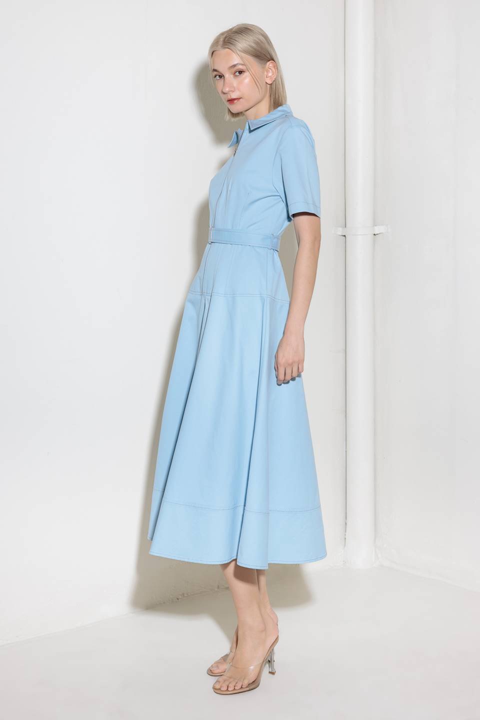 A solid woven shirt dress featuring collar, short sleeve, self belt, circle skirt and front zipper closure.