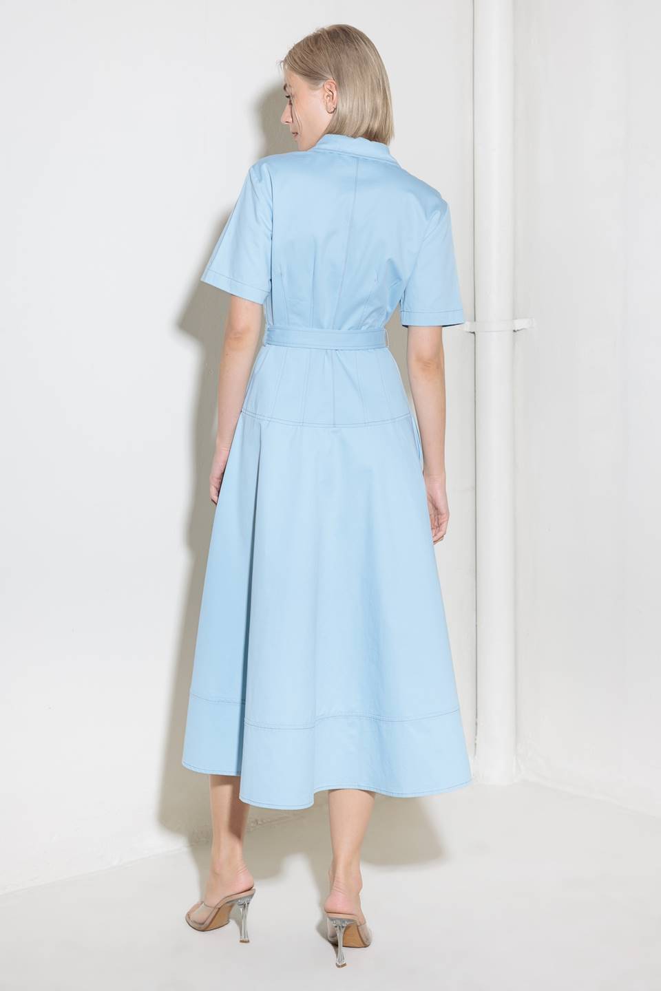 A solid woven shirt dress featuring collar, short sleeve, self belt, circle skirt and front zipper closure.