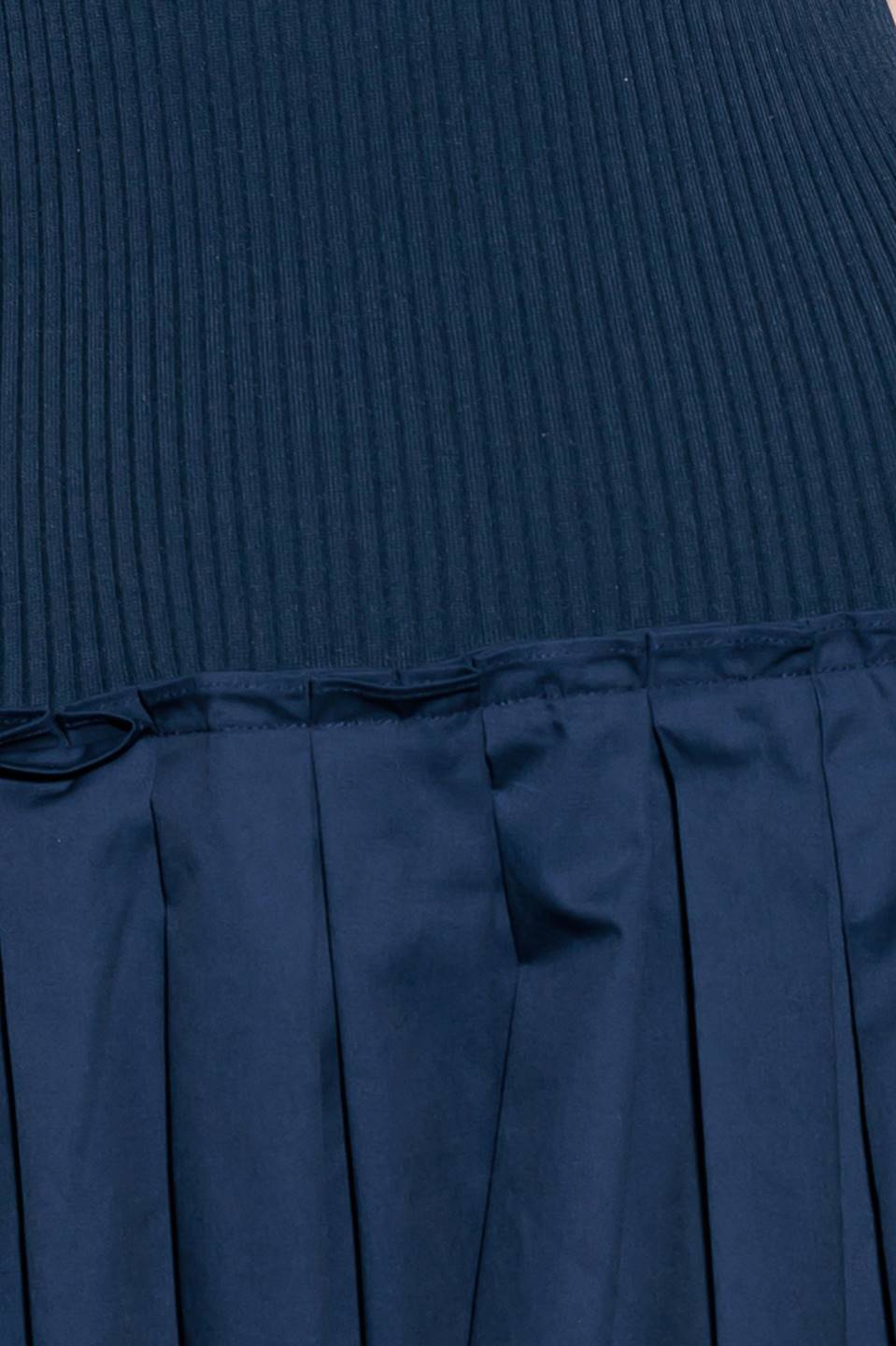 A ribbed sweater knit top and woven skirt combination dress featuring U neckline and sleeveless.