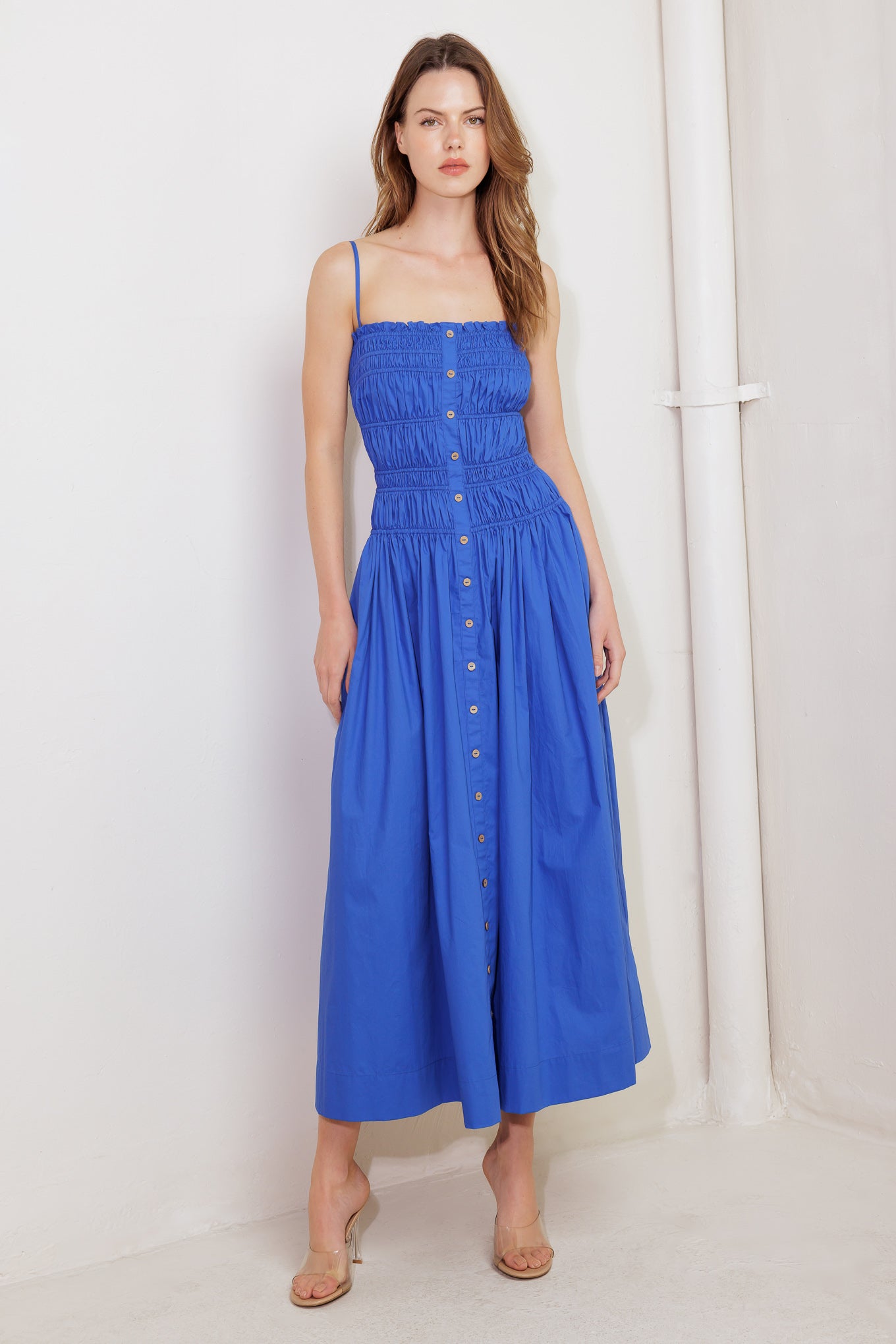 A solid blue woven midi dress featuring straight neckline, straps, button down detail and smocked bodice