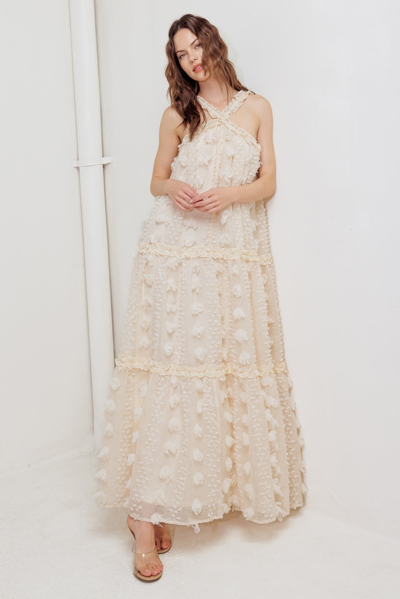 A textured woven ankle dress featuring ruffled cross front and tiered skirt