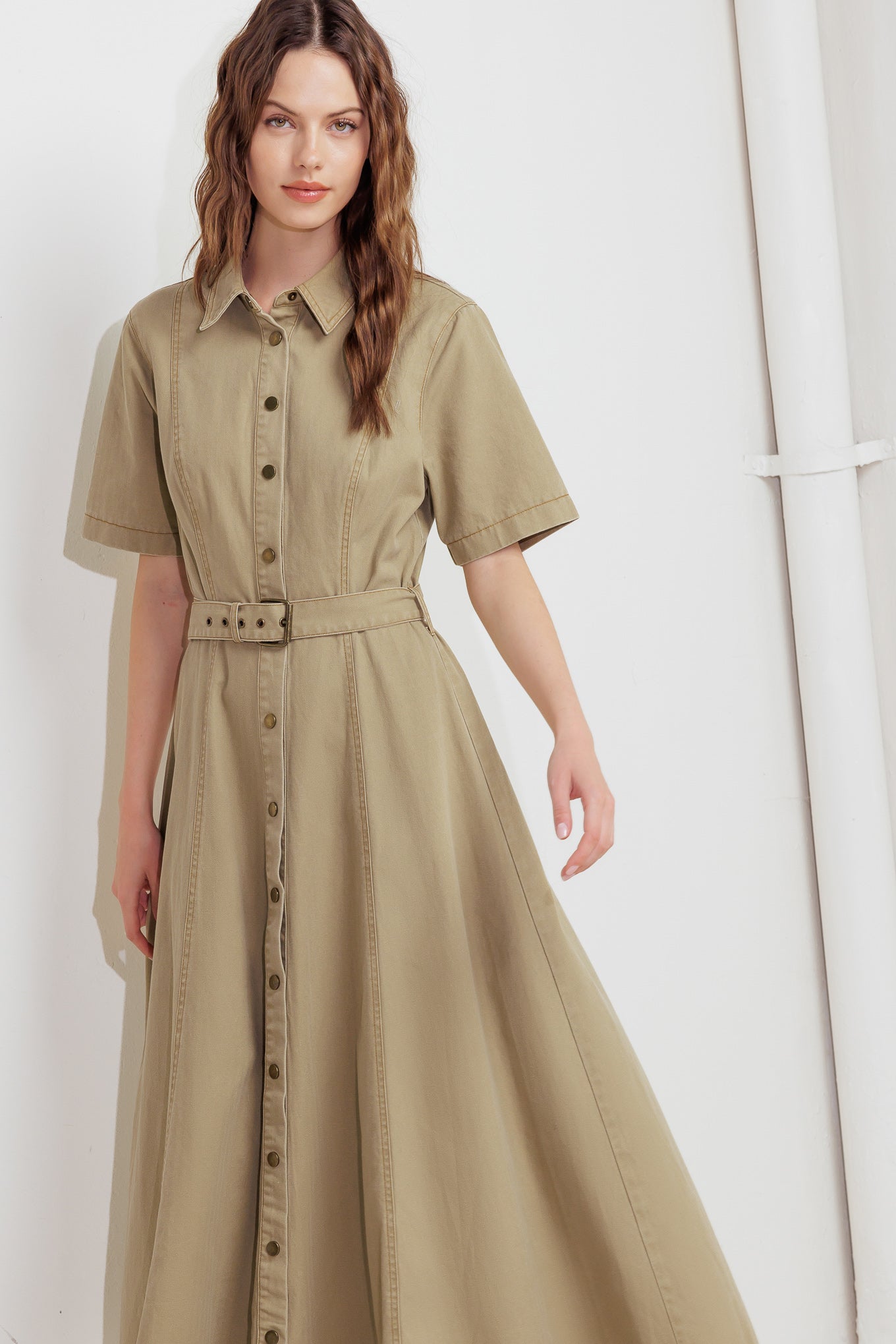 A solid woven midi dress featuring collar, short sleeve, button down, self belt and circle skirt