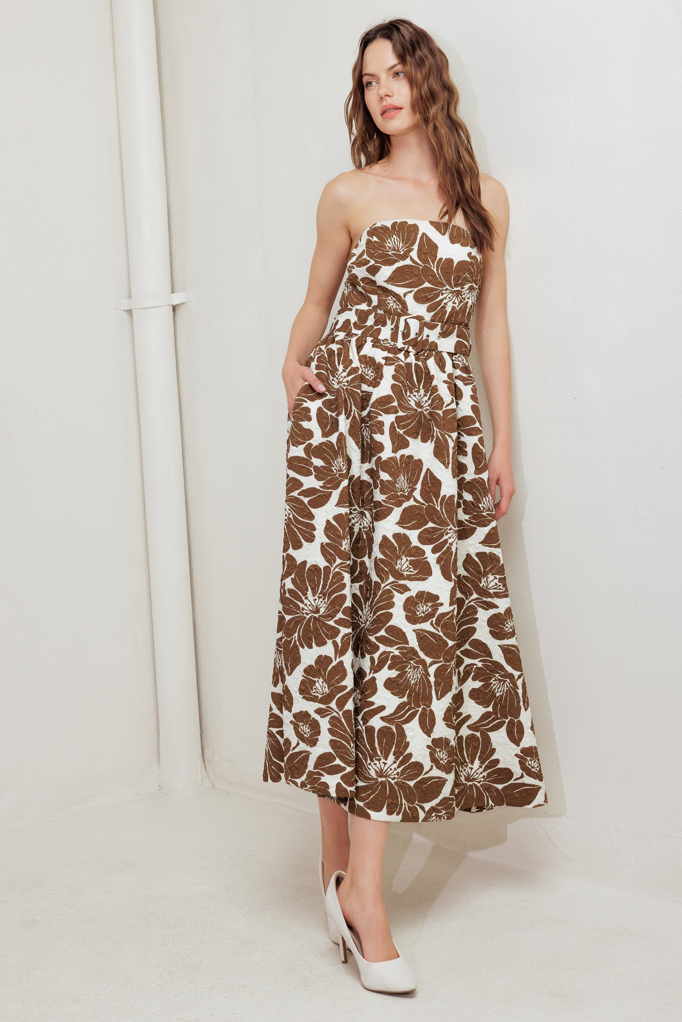 A textured printed woven midi dress featuring strapless, self belt, full skirt and back zipper closure