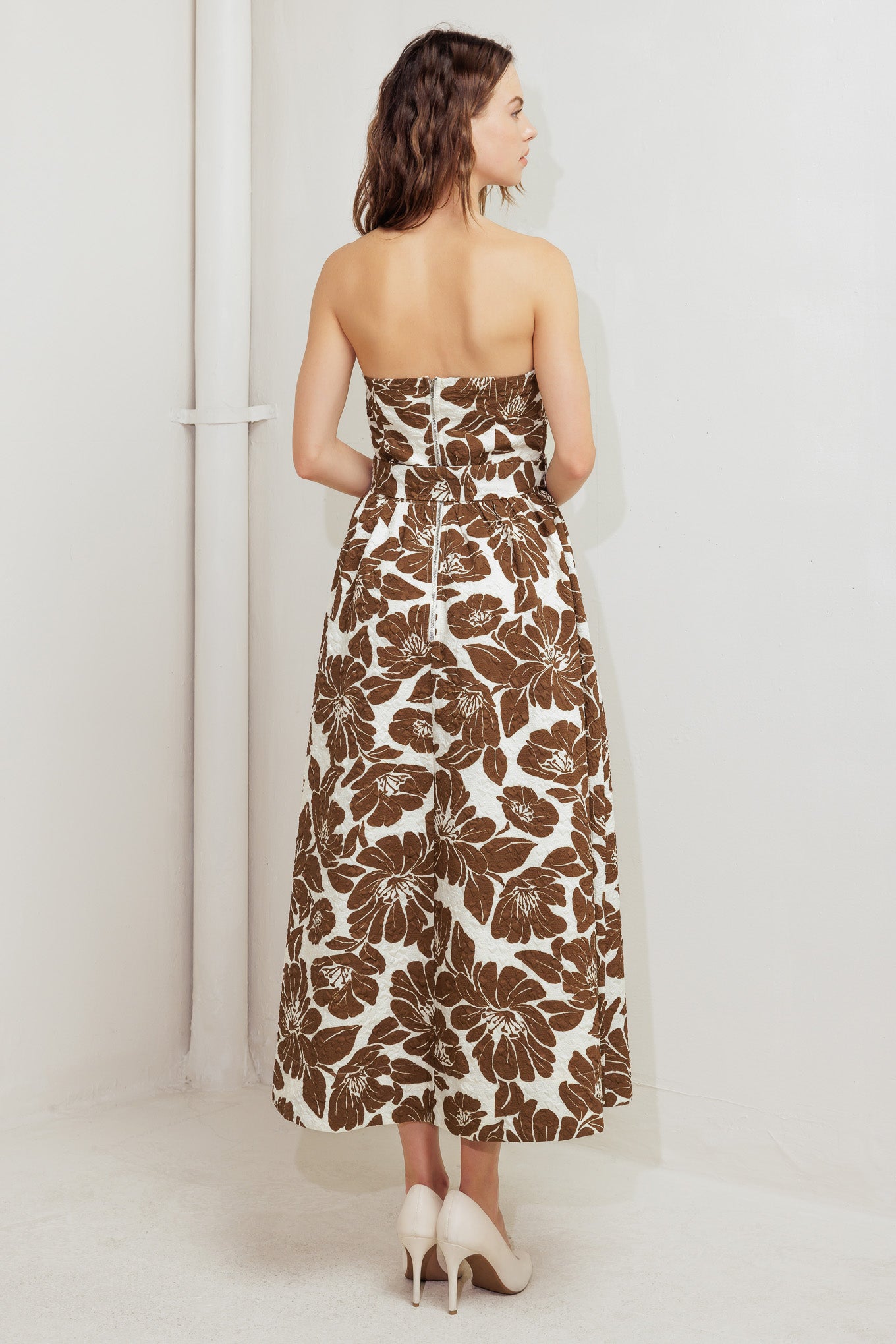A textured printed woven midi dress featuring strapless, self belt, full skirt and back zipper closure