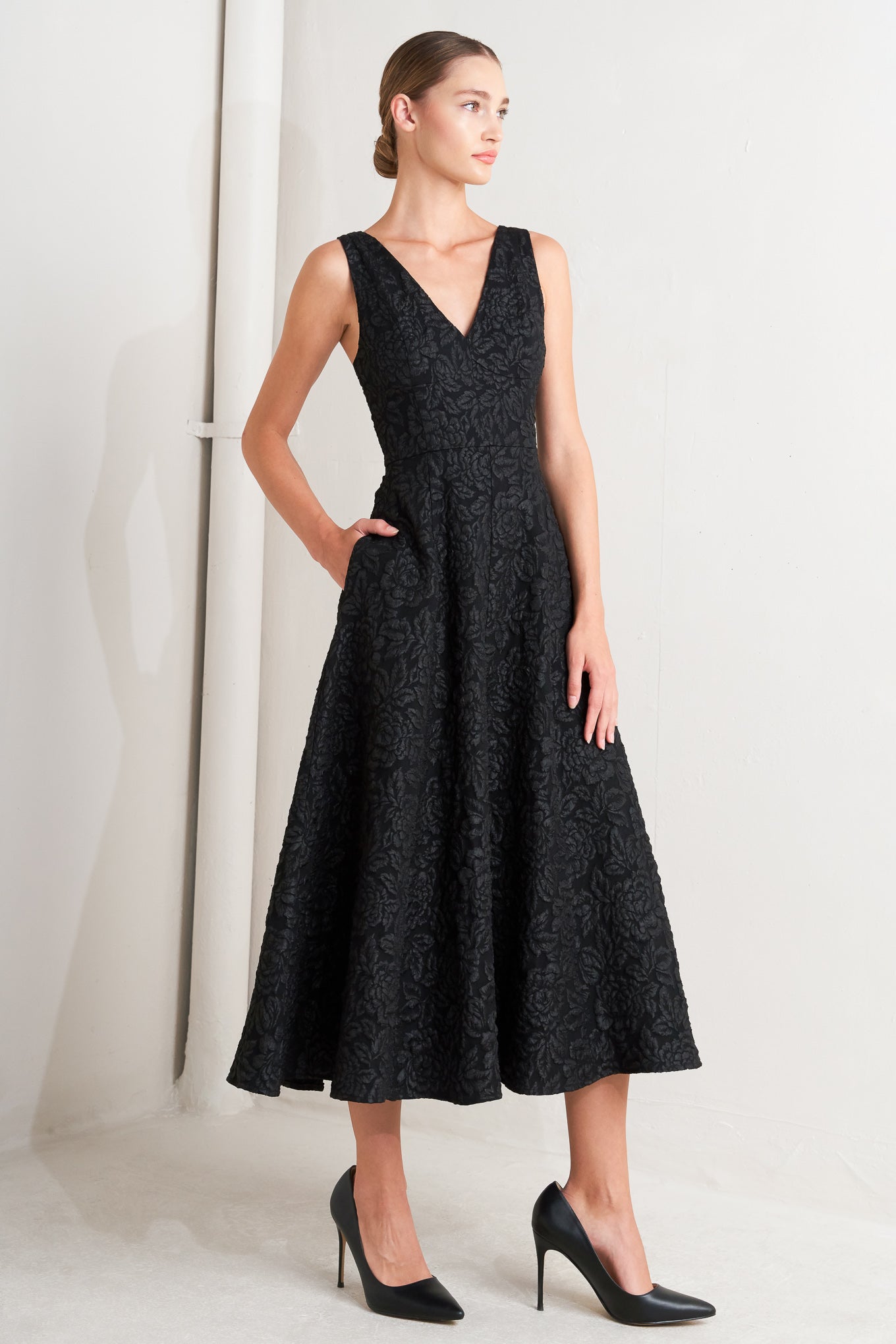 A jacquard woven midi dress featuring V neckline, sleeveless with back strap, circle skirt and back zipper closure