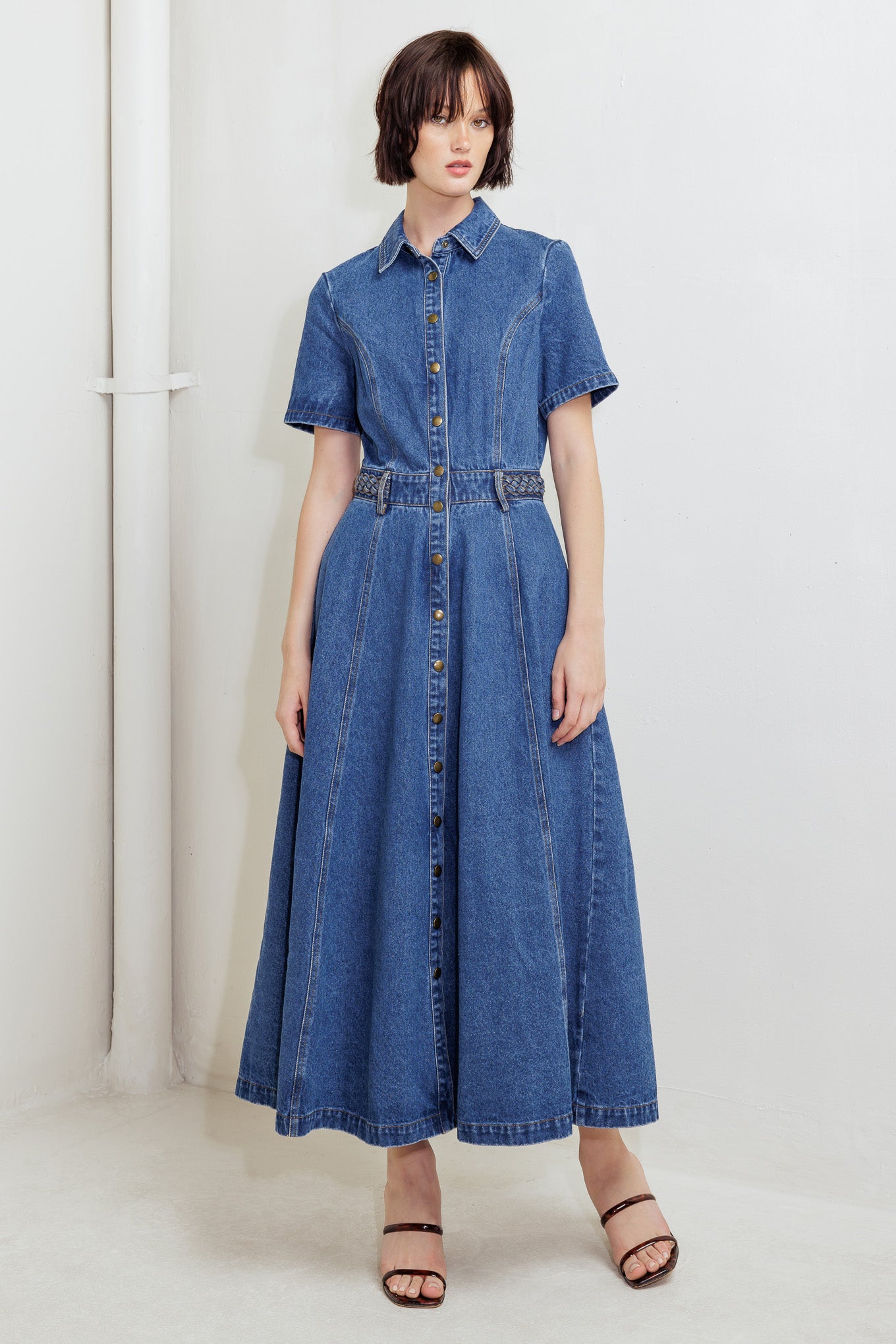 A washed denim midi dress featuring collar, short sleeve, button down, braided waistband and circle skirt