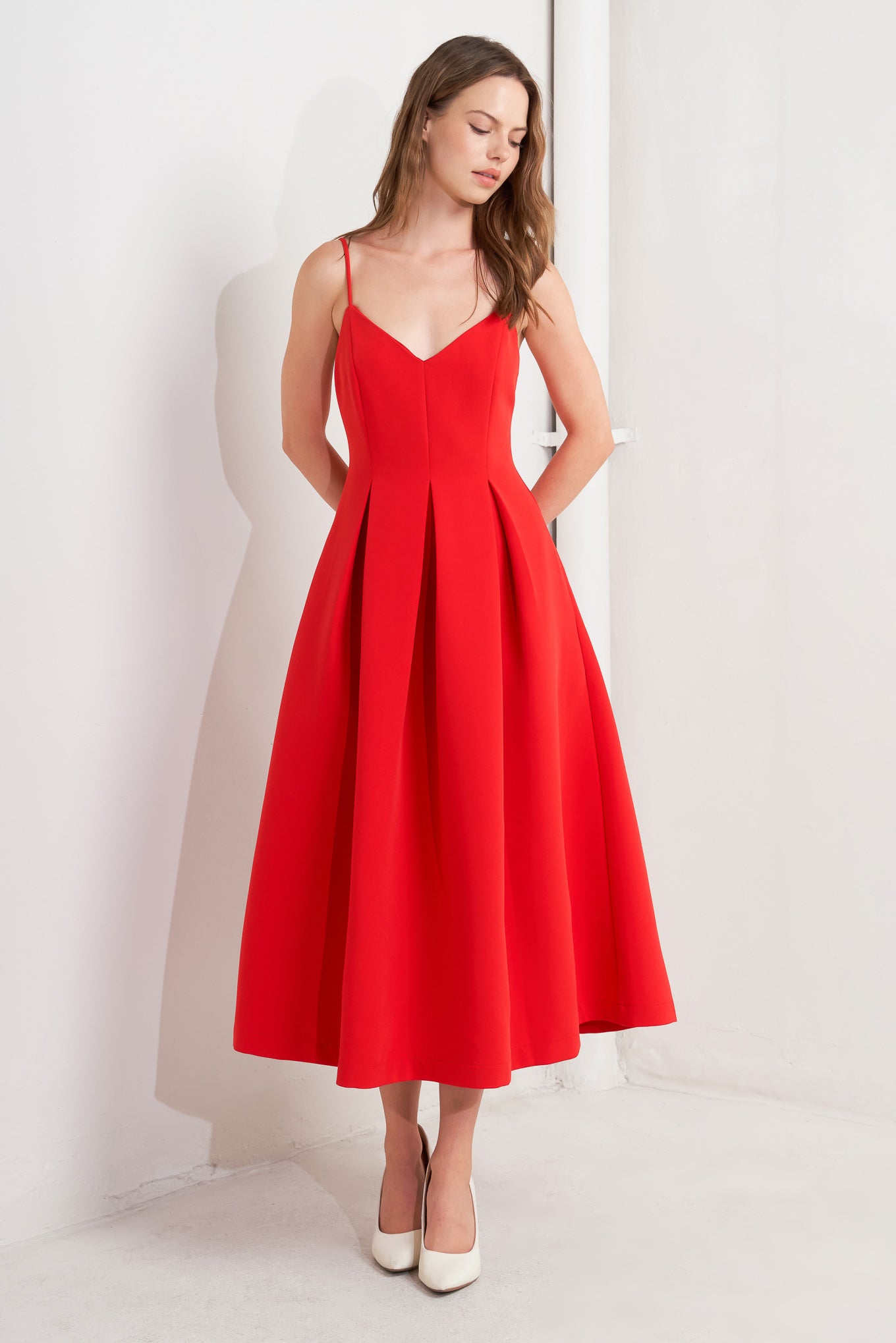 A solid red woven midi dress featuring cami top, full skirt and back zipper closure