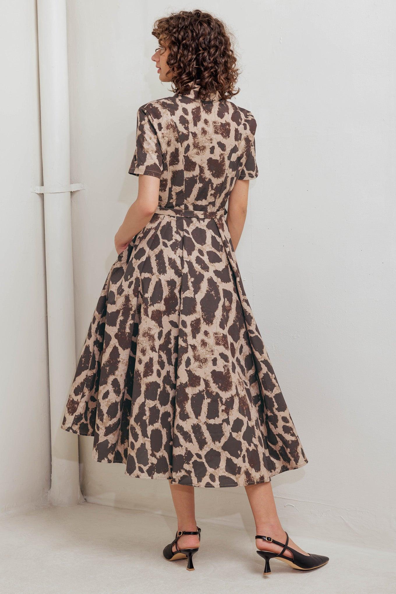 A printed woven midi dress featuring collar, short sleeve, hidden placket with button, self belt and circle skirt