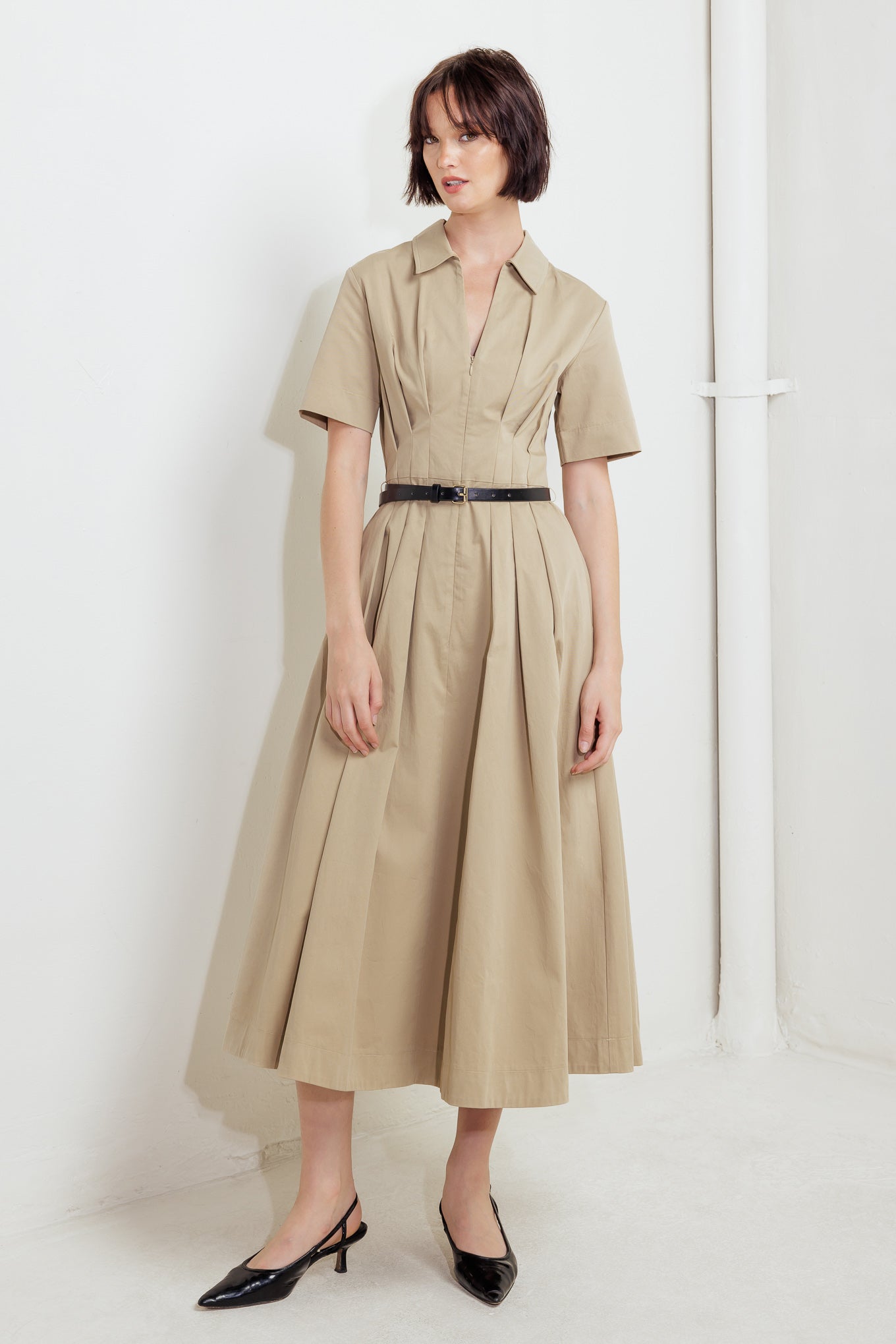 A solid woven midi dress featuring collar, short sleeve, front zipper closure, contrasting belt and full skirt