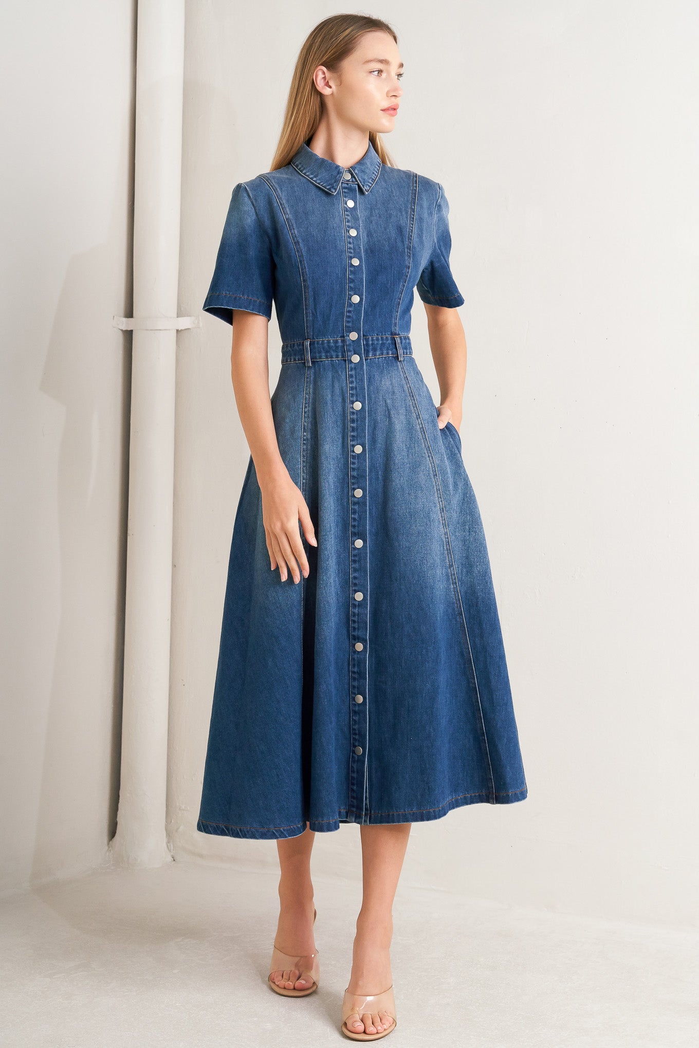 A washed denim midi dress featuring collar, snap button down, short sleeve and circle skirt
