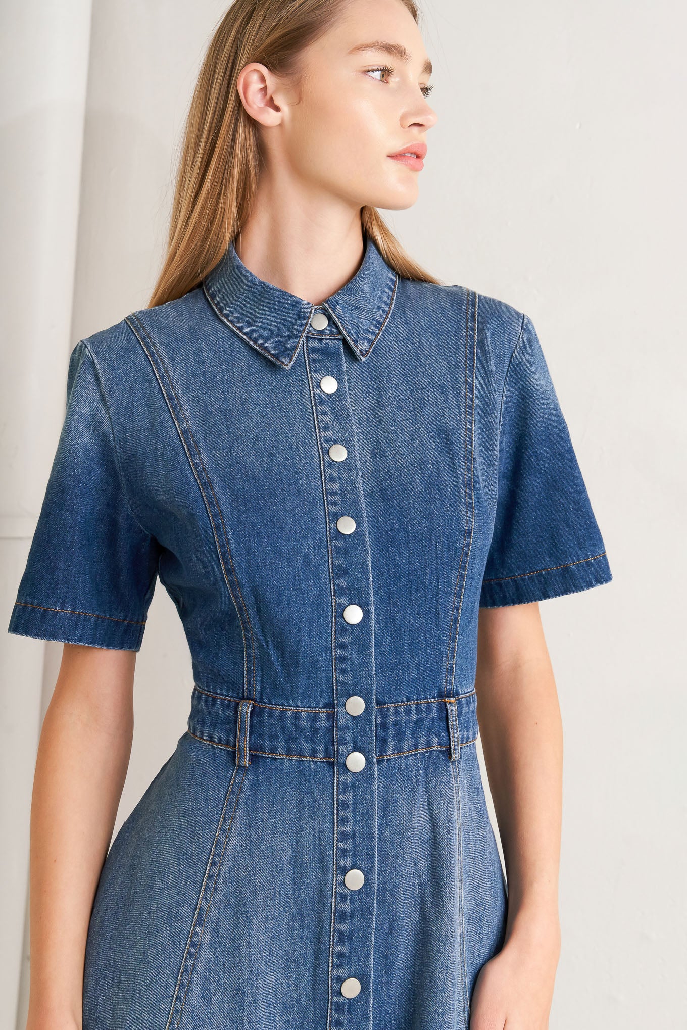A washed denim midi dress featuring collar, snap button down, short sleeve and circle skirt