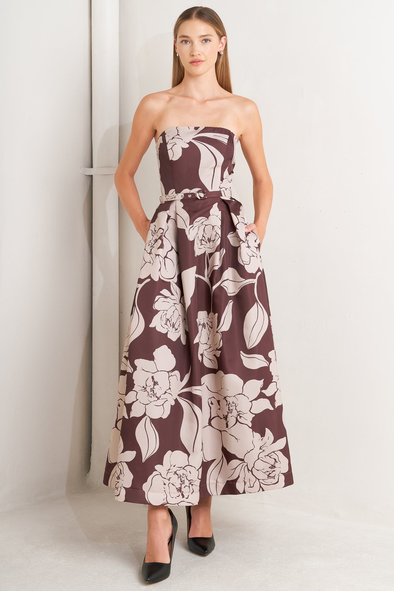 A printed woven midi dress featuring strapless, self belt, full skirt and back zipper closure