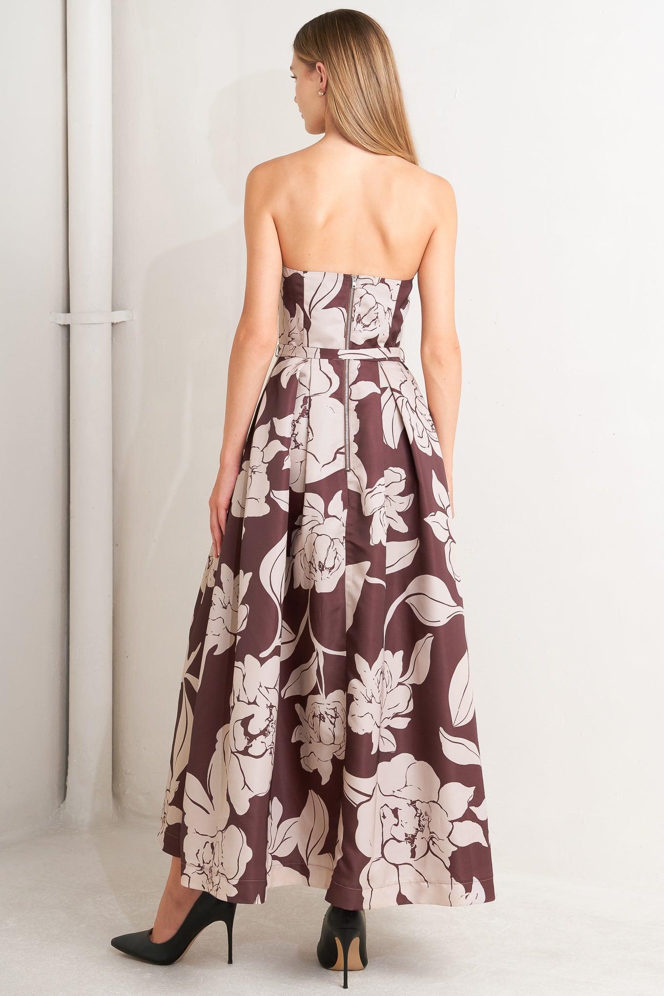 A printed woven midi dress featuring strapless, self belt, full skirt and back zipper closure