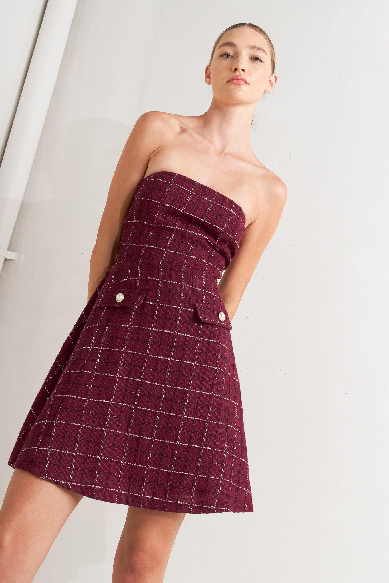 A solid woven midi dress featuring strapless textured woven bodice, full skirt and back zipper closure