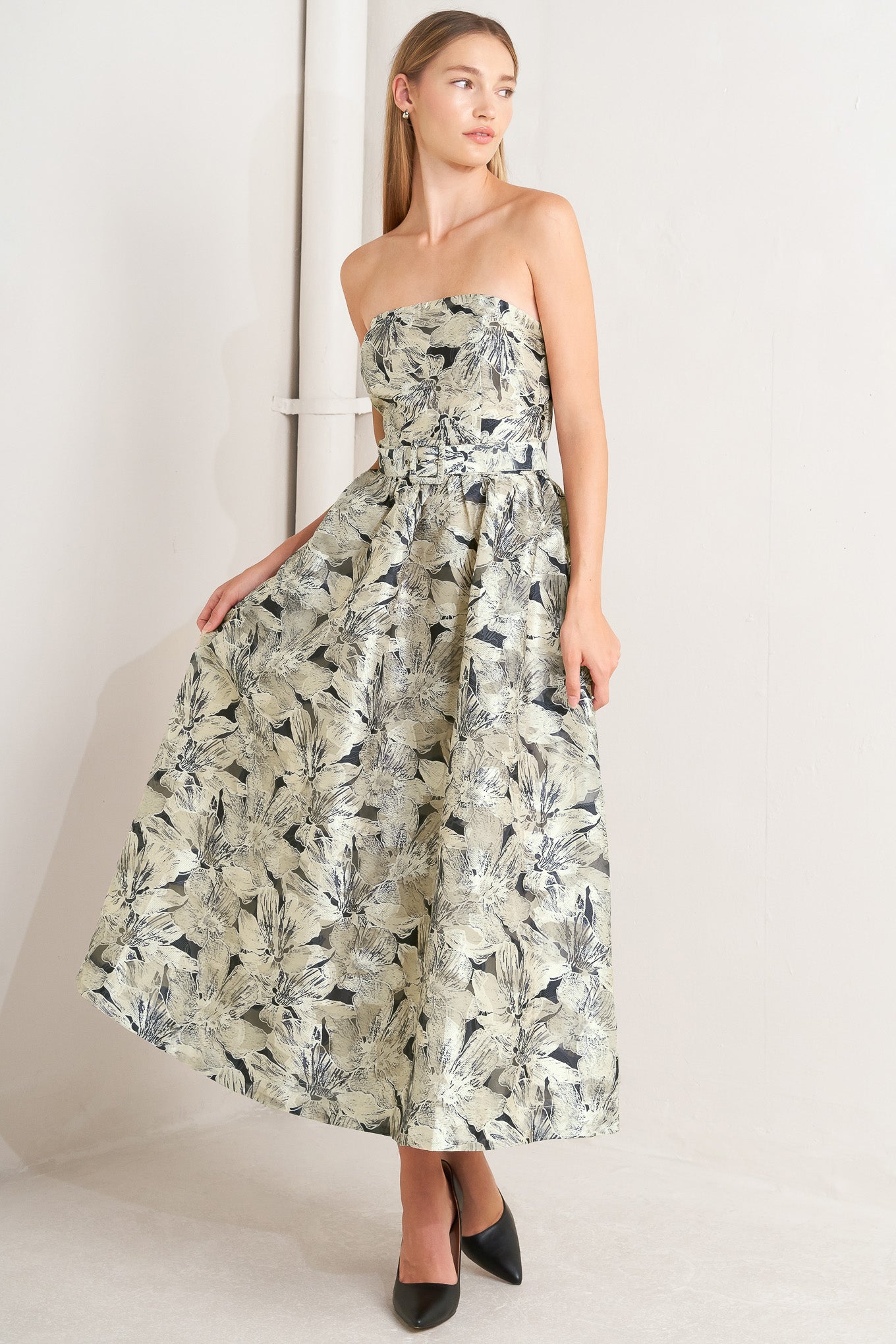 A textured woven midi dress featuring strapless, self belt, full skirt and back zipper closure