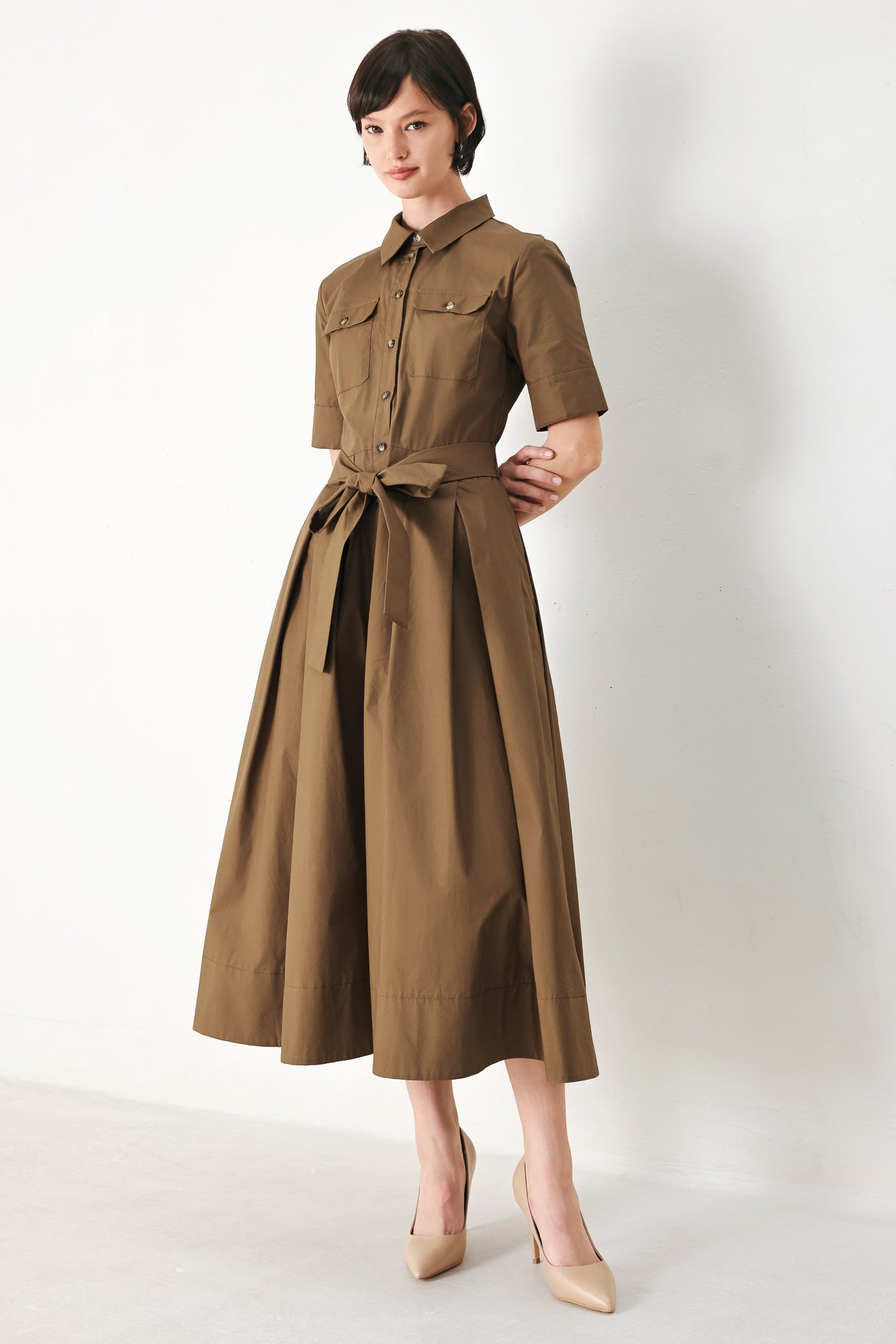 A solid brown woven midi shirt dress with short sleeve, pockets, self tie and front closure