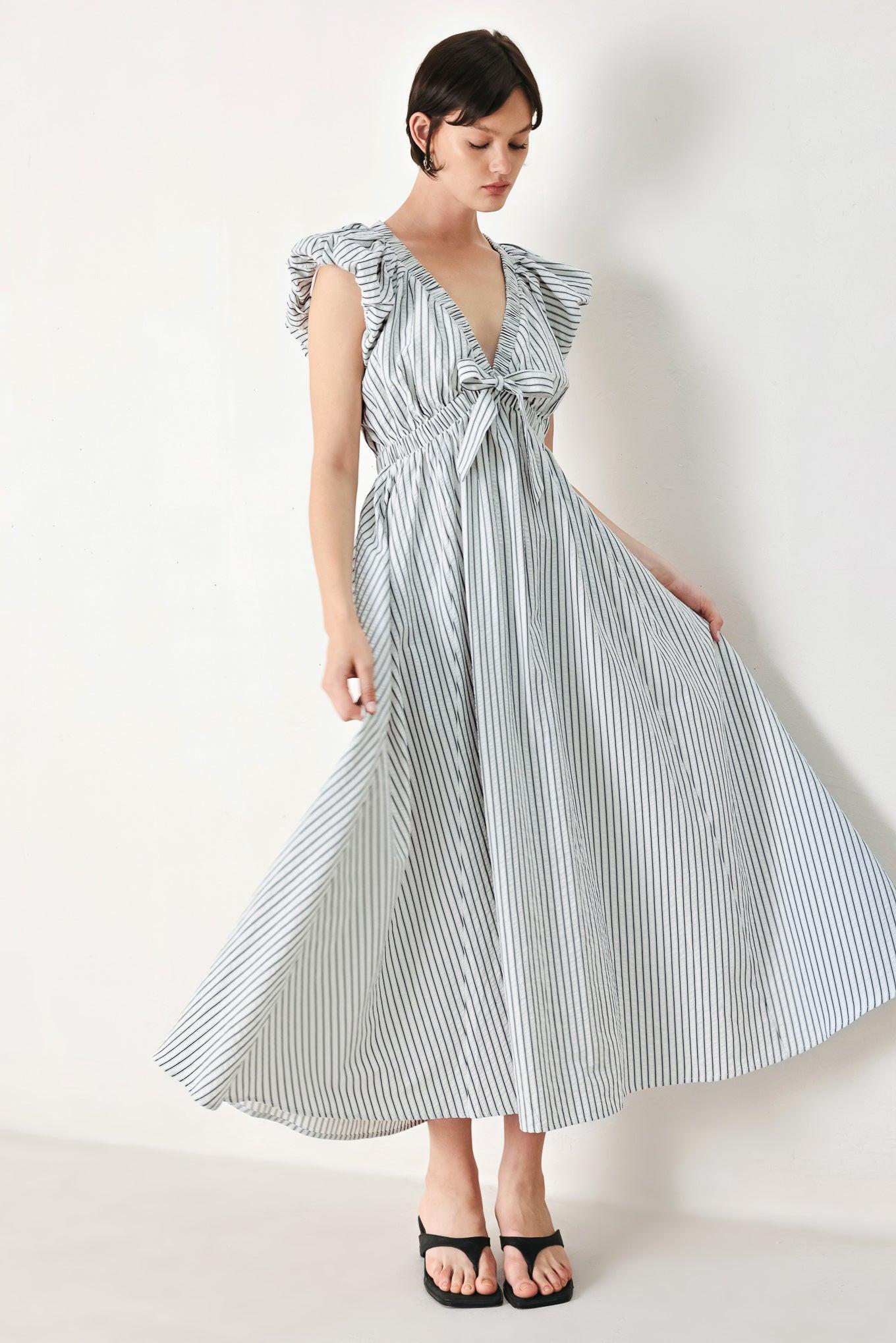 A striped woven midi dress featuring V neckline, short balloon sleeves, front tie, elastic at empire and full skirt